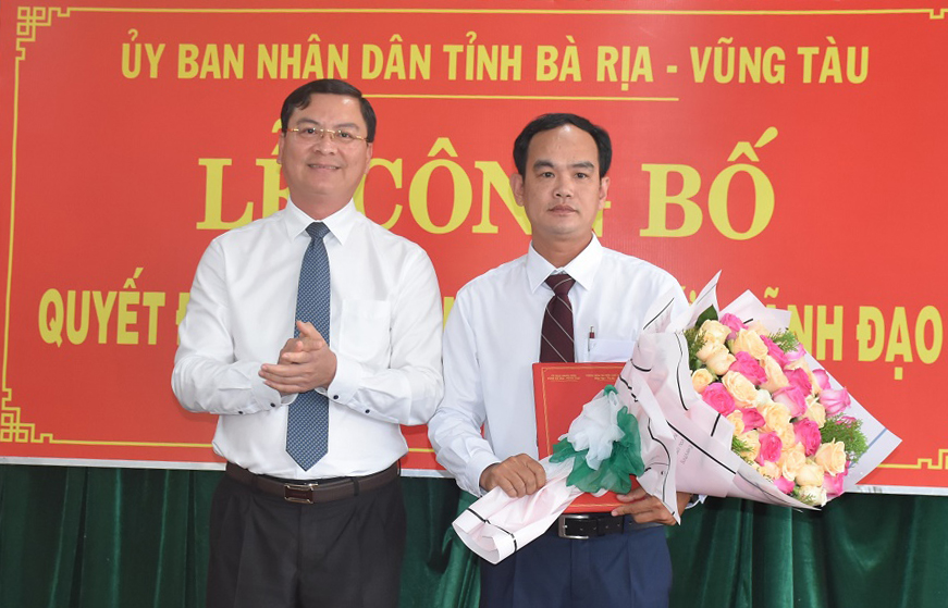 Ông Nguyễn Công Vinh, Phó Chủ tịch UBND tỉnh trao quyết định và tặng hoa chúc mừng ông  Đỗ Minh Tuấn.