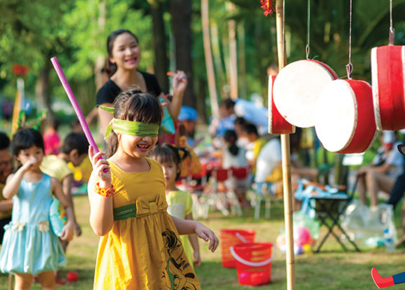 Du khách “nhí” chơi đánh trống trong tour Fun Farm của Hồ Mây Park.