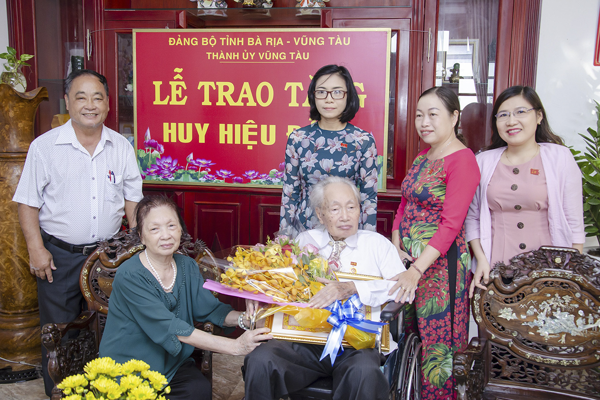 Lãnh đạo TP. Vũng Tàu cùng cán bộ Chi bộ 1, Đảng bộ phường 1 trao Huy hiệu 60 năm tuổi Đảng và tặng hoa chúc mừng ông Trần Năng Luân.