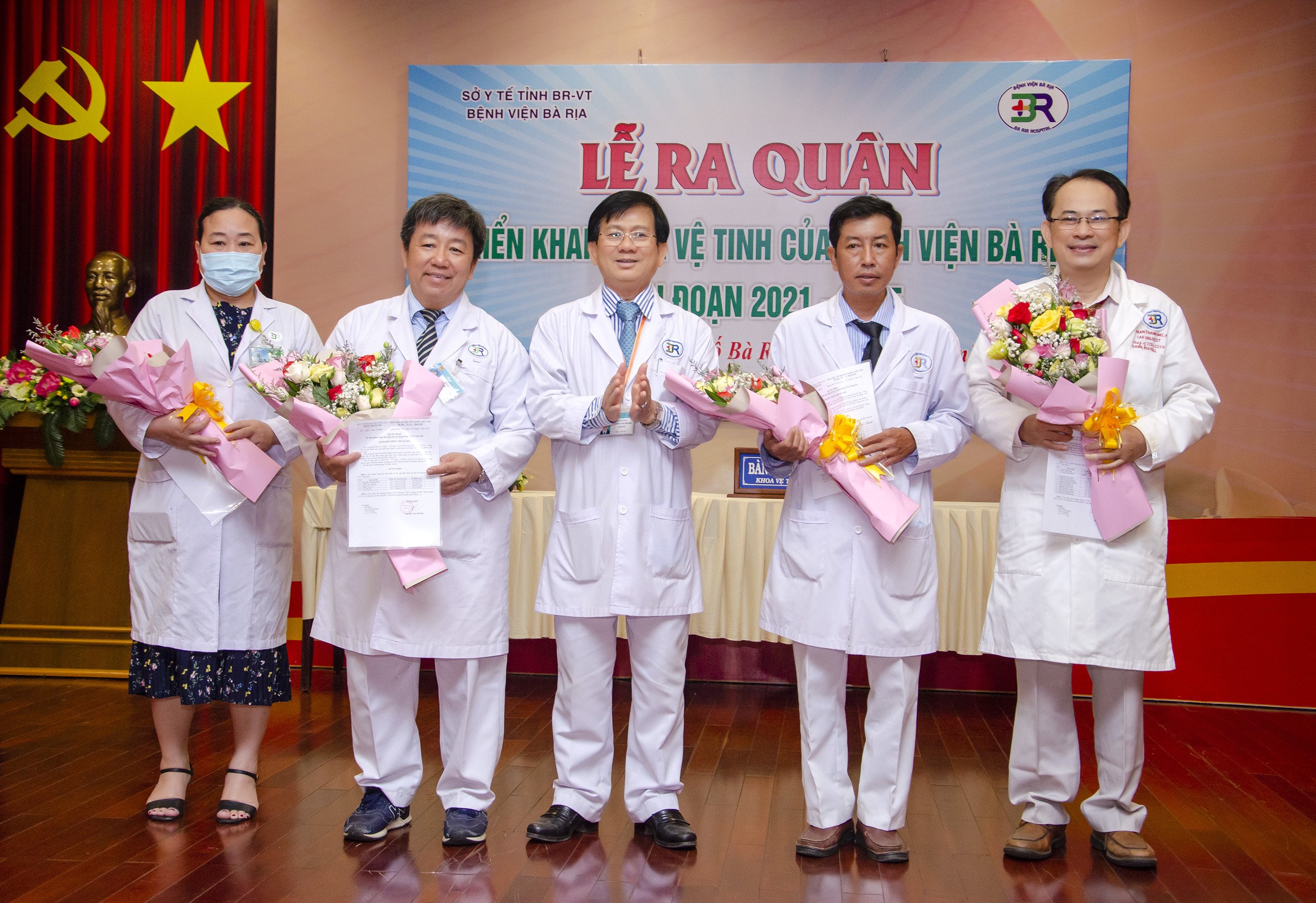 Bác sĩ Nguyễn Văn Hương, Giám đốc Bệnh viện Bà Rịa trao Quyết định và tặng hoa chúc mừng các Khoa có viên chức được cử đi luân phiên về hỗ trợ các bệnh viện tuyến dưới.