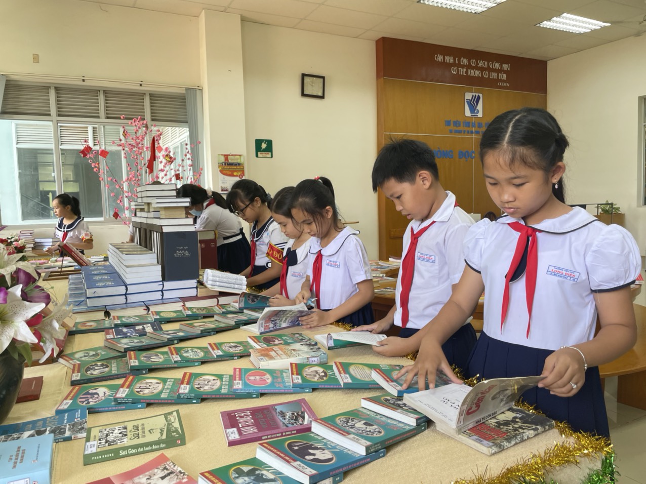 Các em HS xem sách tại buổi khai mạc Tuần lễ đọc sách sáng 16/4.