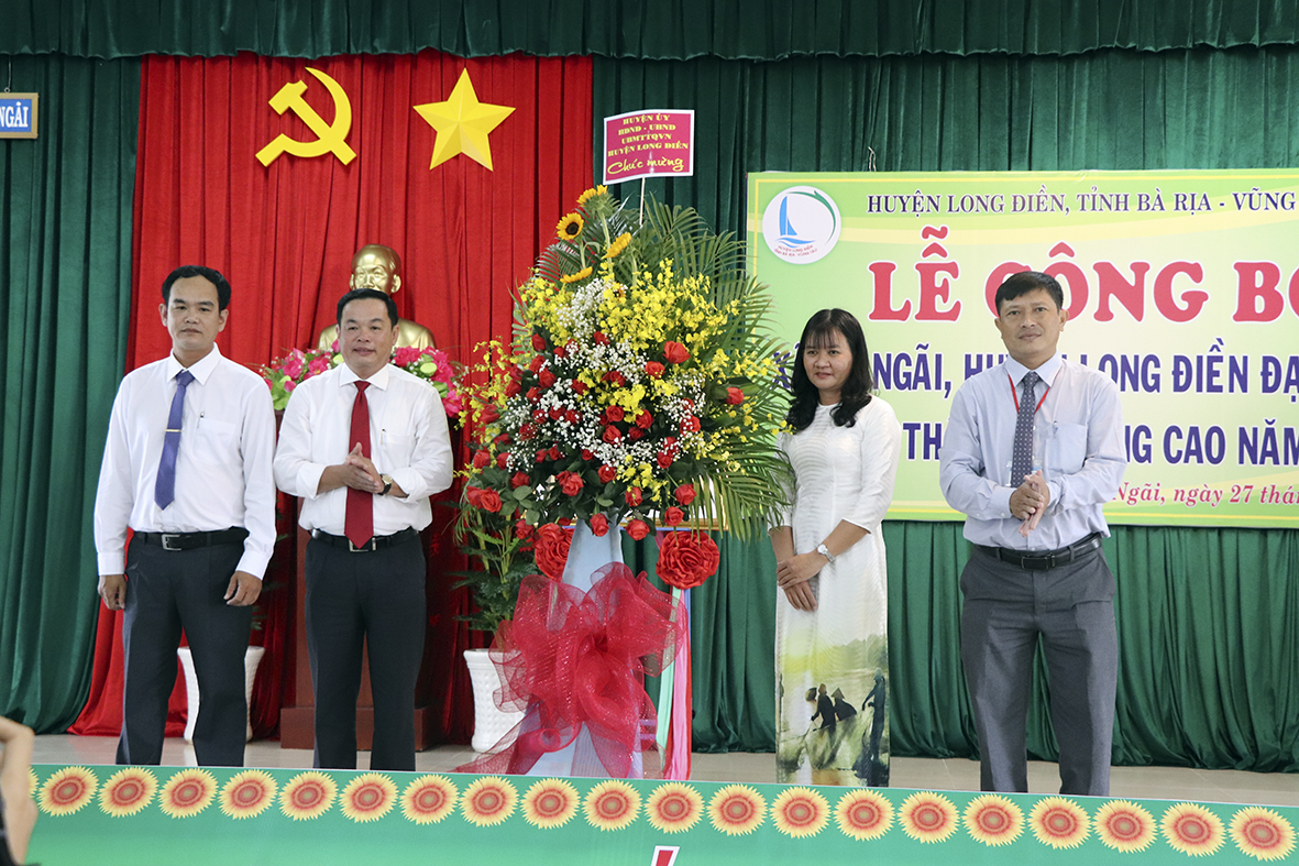 Ông Nguyễn Bá Hùng (thứ hai từ trái vào), Chủ tịch UBND huyện Long Điền tặng hoa chúc mừng xã An Ngãi được công nhận đạt chuẩn NTM nâng cao.