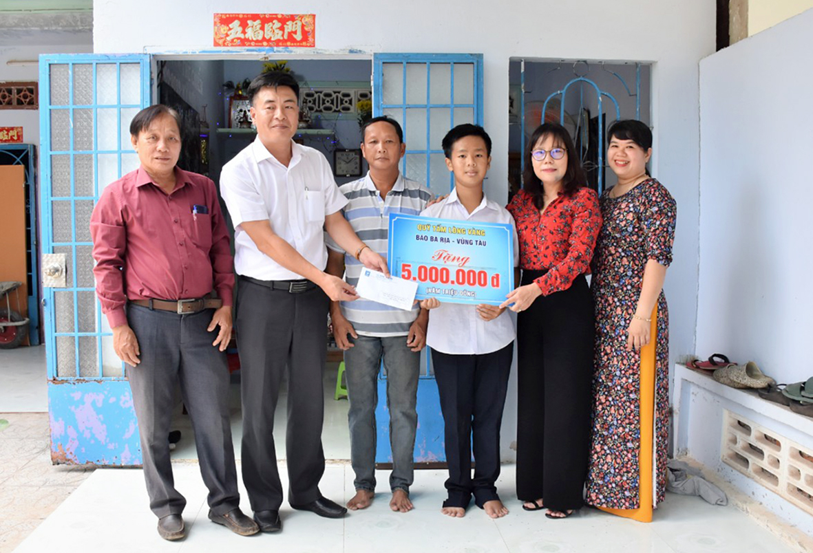 Bà Đỗ Nguyễn Hoàng Dung, Quyền Tổng Biên tập Báo Bà Rịa-Vũng Tàu (thứ 2 từ phải qua) trao số tiền 5 triệu đồng từ Quỹ “Tấm lòng vàng” cho em Huỳnh Thái Bảo (khu phố 1, phường Hắc Dịch, TX.Phú Mỹ).
