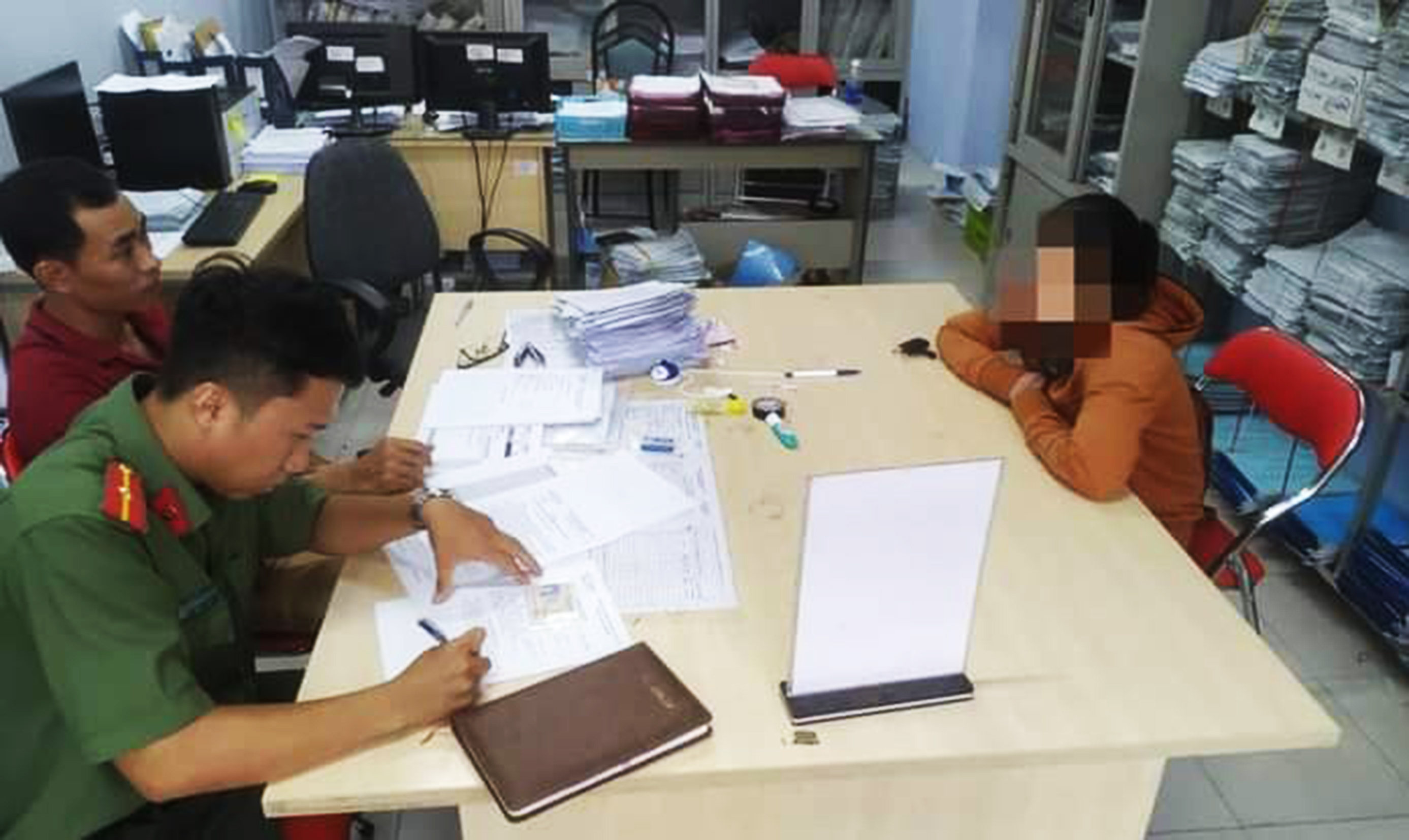 Lực lượng công an làm việc với bà P.T.H (phải). 