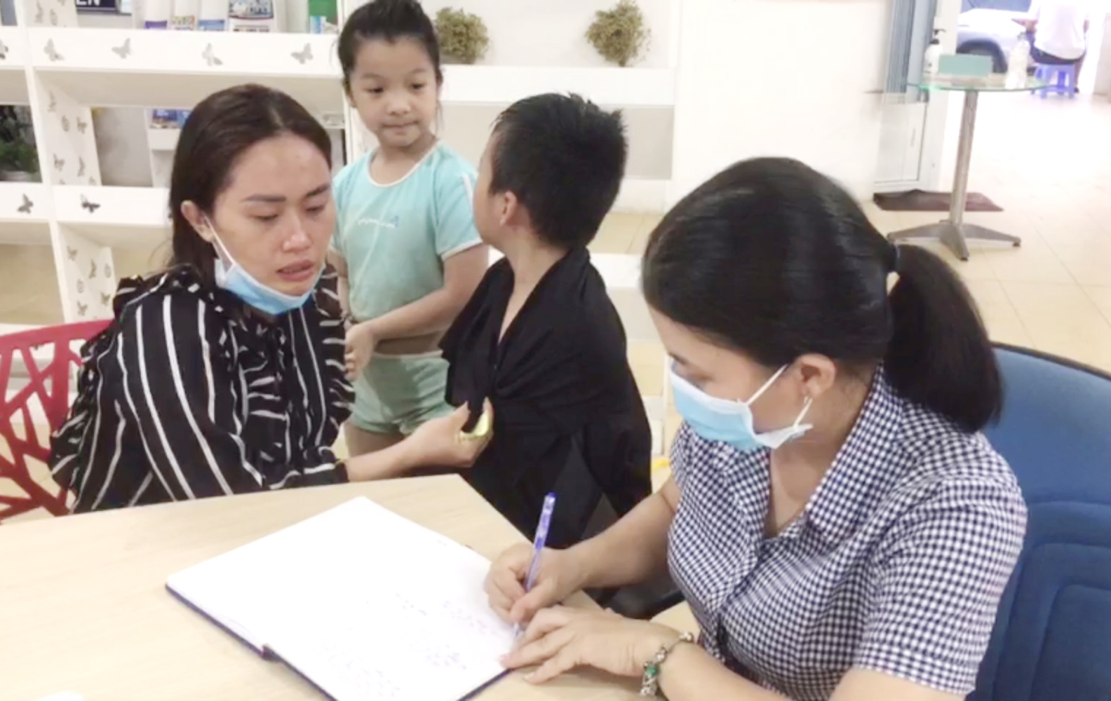 Nhân viên Trung tâm Quản lý và Hỗ trợ khách du lịch TP. Vũng Tàu làm thủ tục bàn giao trẻ đi lạc cho gia đình. 