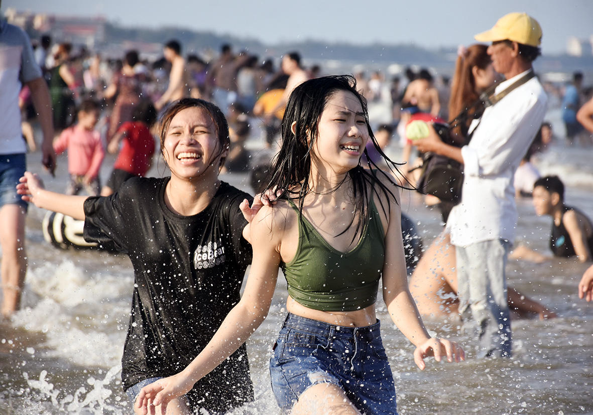 Du khách vui đùa với sóng biển Bãi Sau.