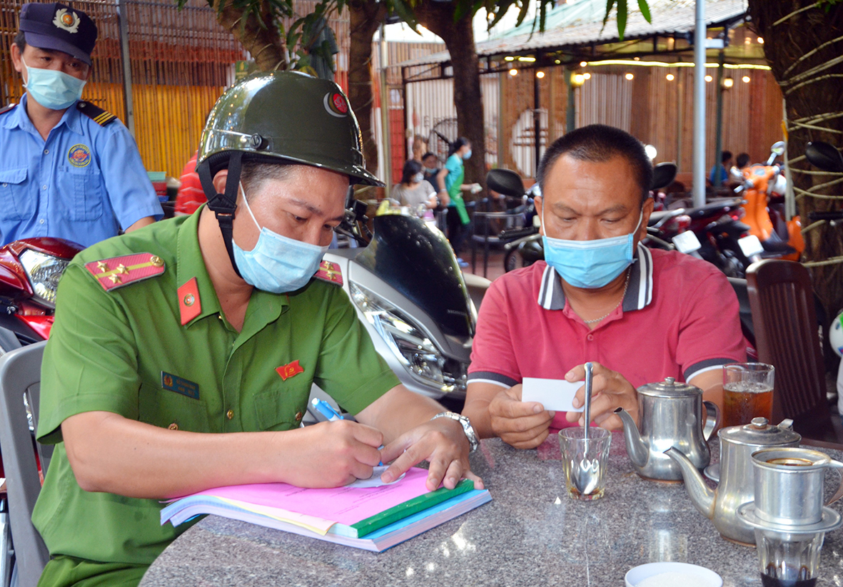 Lực lượng chức năng lập biên bản xử phạt một trường hợp không thực hiện đeo khẩu trang sau khi được nhắc nhở tại một quán cà phê ở phường 1, TP.Vũng Tàu).