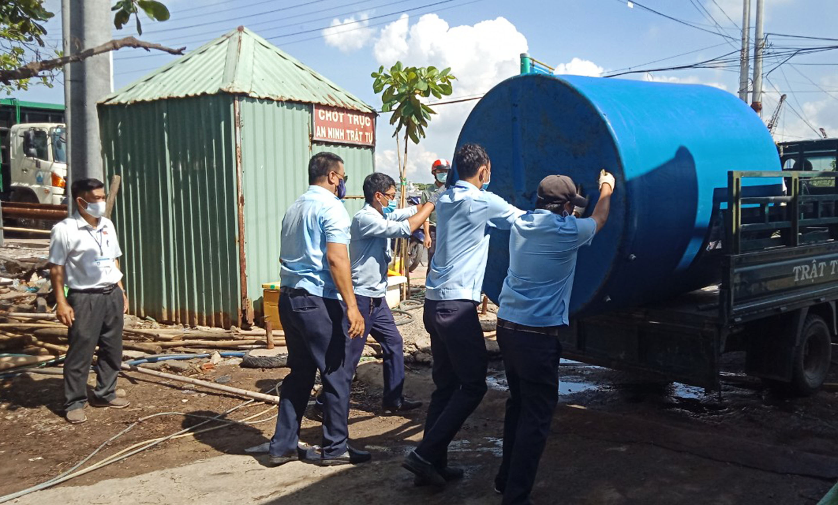 Các lực lượng chức năng di dời các bồn chứa nước đặt trái phép tại chân cầu Rạch Bà.