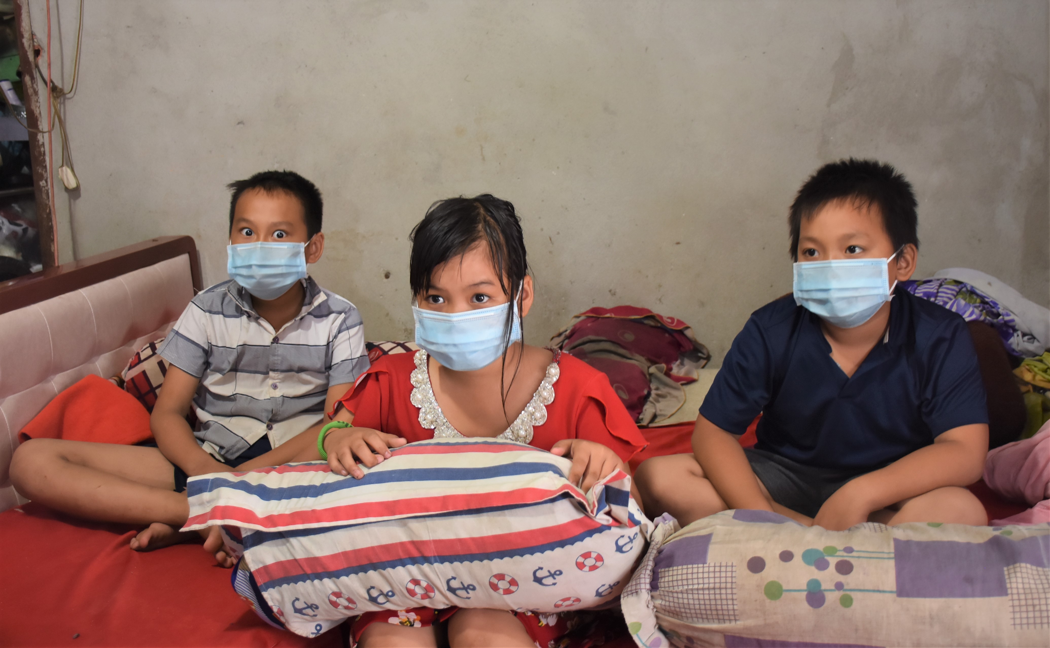 (Từ trái qua) 3 anh em Hồ Hoàng Văn Long (11 tuổi), Hồ Hoàng Sương Nhi (10 tuổi) và Hồ Hoàng Thanh Sơn (9 tuổi) tự chăm sóc nhau những ngày mẹ nằm viện.