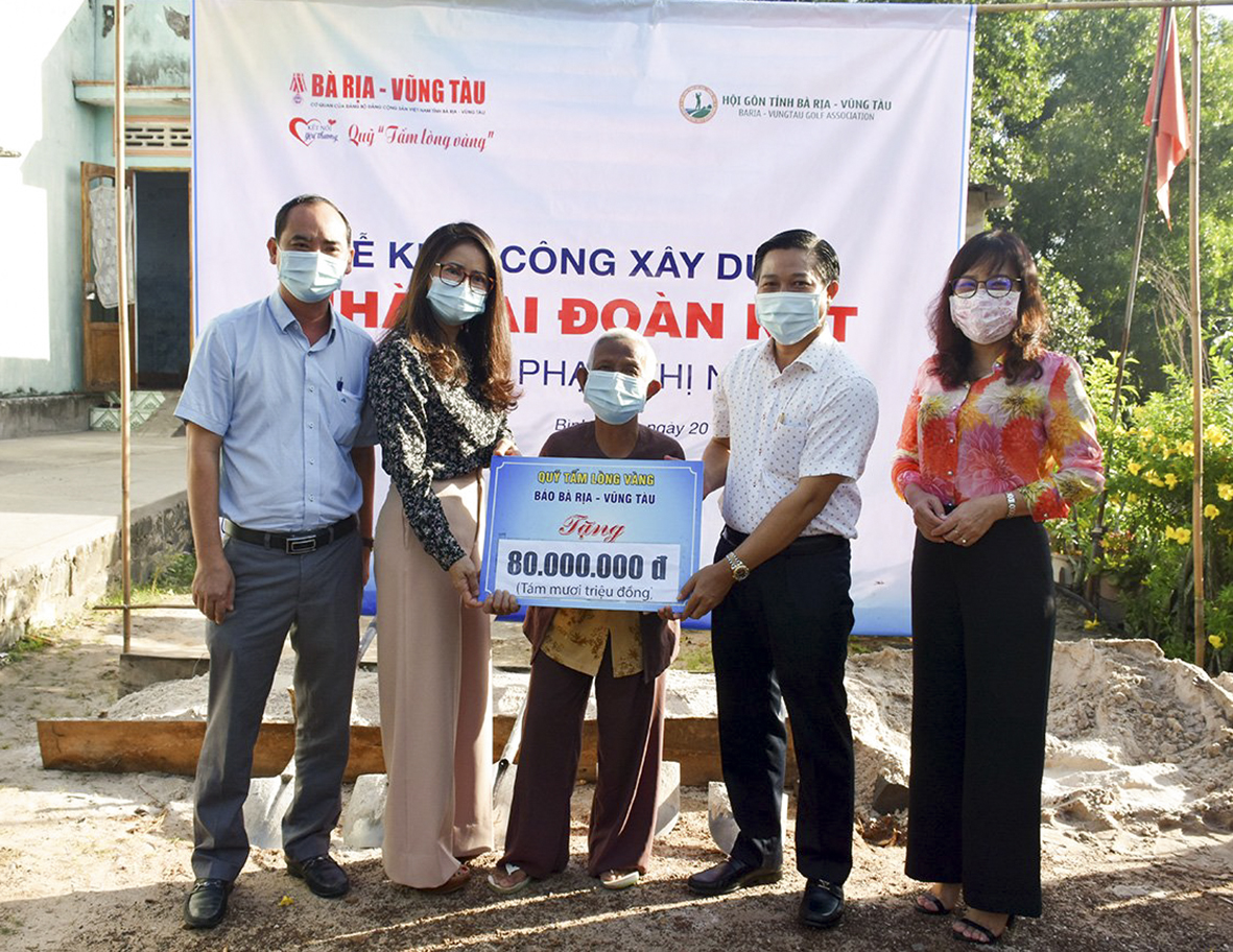 Bà Lê Thị Trang Đài, Chủ tịch UBND huyện Xuyên Mộc (thứ hai từ trái qua), bà Đỗ Nguyễn Hoàng Dung, Quyền Tổng biên tập Báo BR-VT (thứ nhất từ phải qua), ông Lê Đình Thắng, Phó Chủ tịch Hội Golf tỉnh (thứ hai từ phải qua) trao tiễn hỗ trợ xây nhà Đại đoàn kết cho bà Phạm Thị Nhàn.