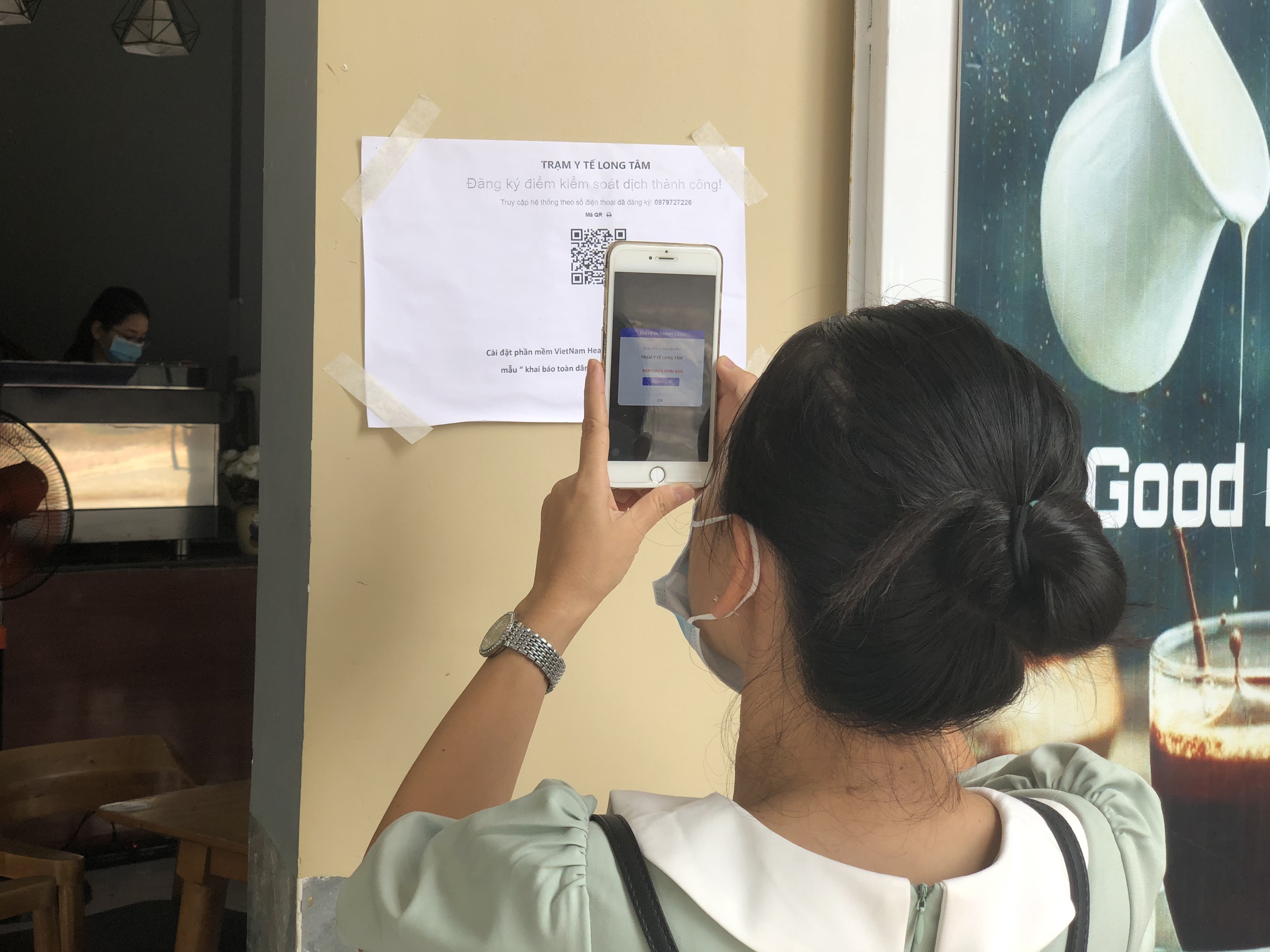 Một người dân khai báo y tế bằng mã QR-Code tại một quán cà phê.
