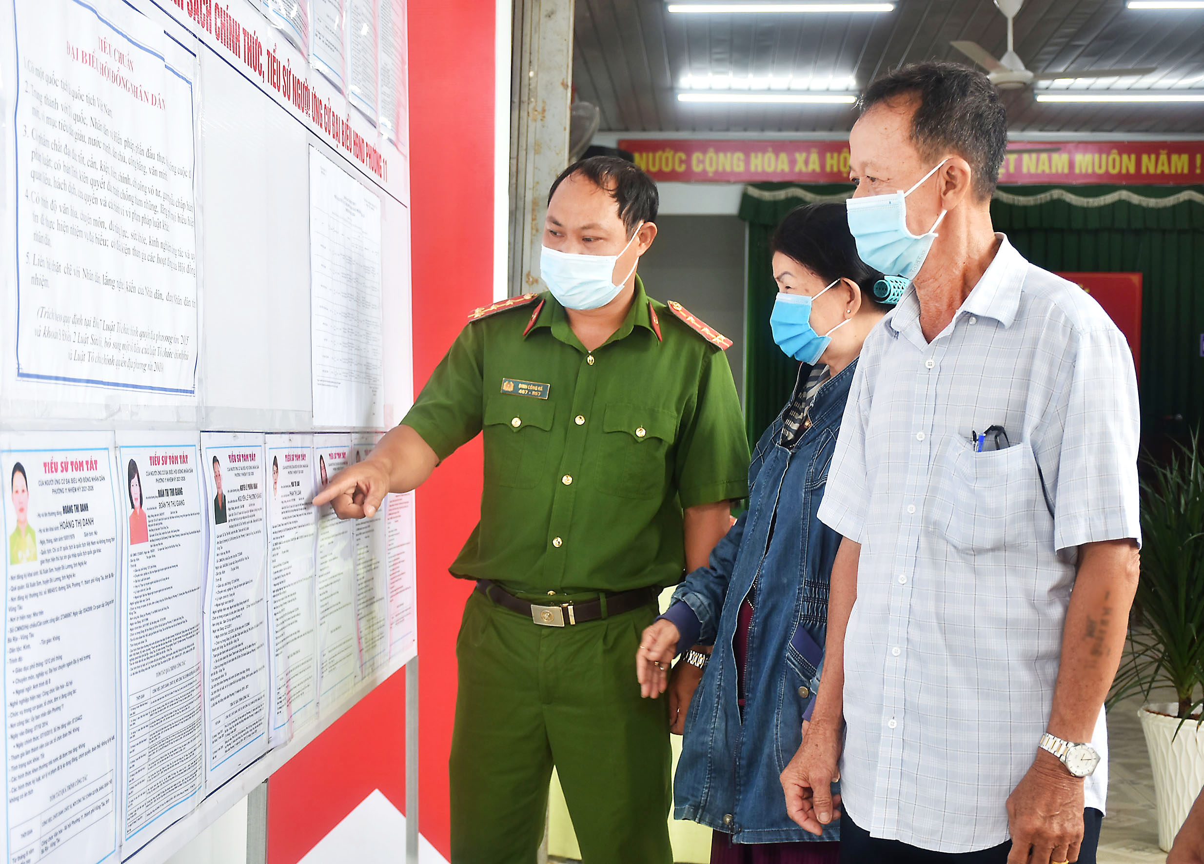 Công an phường 11, TP. Vũng Tàu hướng dẫn cử tri xem thông tin về ứng cử viên được niêm yết tại khu vực bỏ phiếu số 1, KP1.