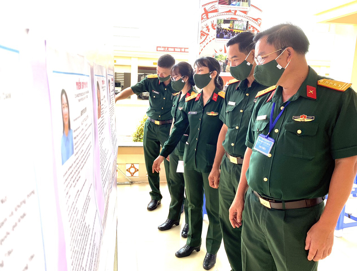 Cán bộ, chiến sĩ xem danh sách ứng cử ĐBQH khóa XV và HĐND các cấp nhiệm kỳ 2021-2026 tại khu vực bỏ phiếu số 12, Bộ CHQS tỉnh. Ảnh: MINH NHÂN