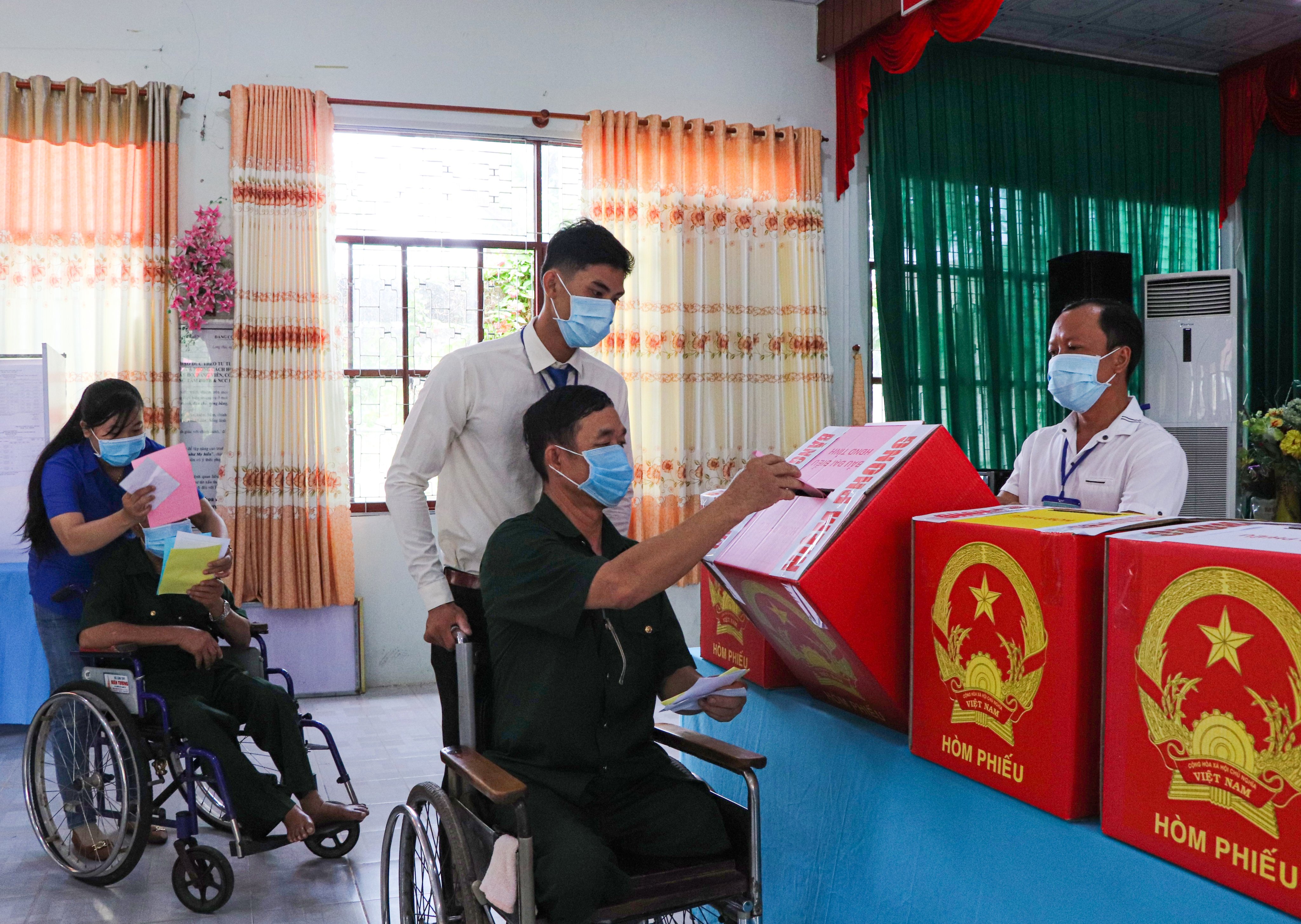 Các thương bệnh binh tại Trung tâm Điều dưỡng thương binh và người có công Long Đất được Tổ bầu cử và ĐVTN hỗ trợ để bỏ phiếu, thực hiện quyền công dân của mình.