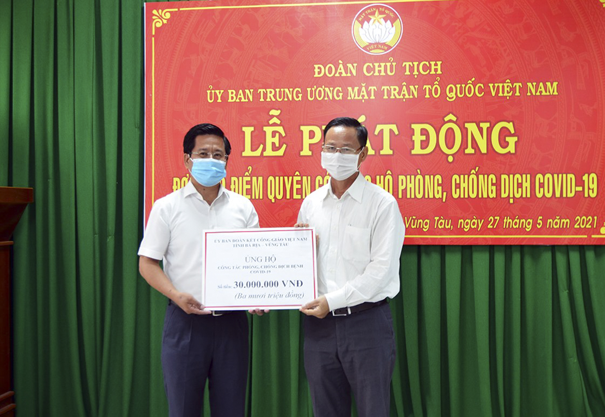 Ông Vũ Văn Phúc, Phó Chủ tịch Ủy ban Đoàn kết Công giáo tỉnh (bên phải) trao bảng tượng trưng số tiền hỗ trợ công tác phòng, chống dịch COVID 19.