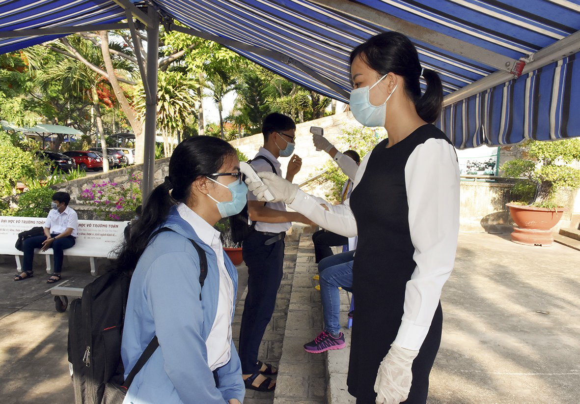 Các thí sinh được kiểm tra thân nhiệt trước khi vào phòng thi tại điểm thi Trường THPT Vũng Tàu.
