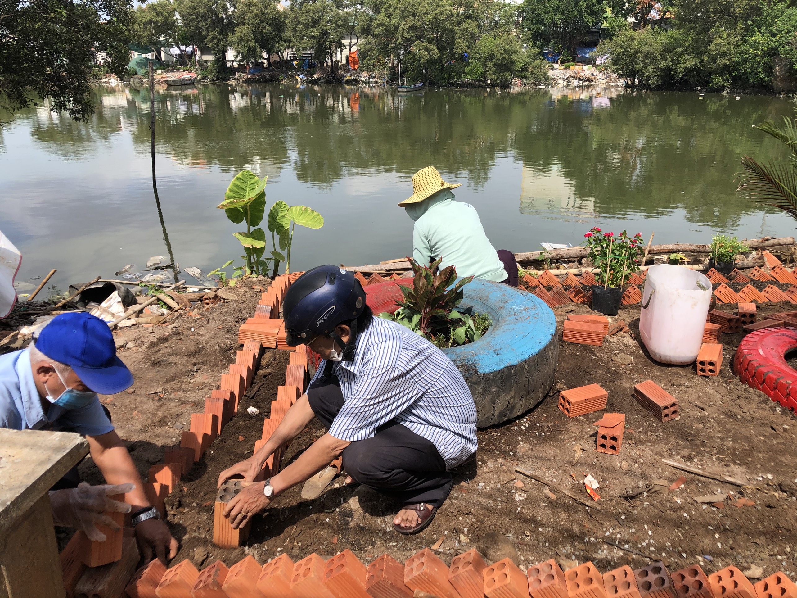 Cây xanh được trồng còn nhằm bảo vệ bờ kênh xanh - sạch - đẹp. Trong ảnh: Cán bộ UBMTTQVN phường 11 cùng khu phố trồng cây xanh ven bờ kênh. 