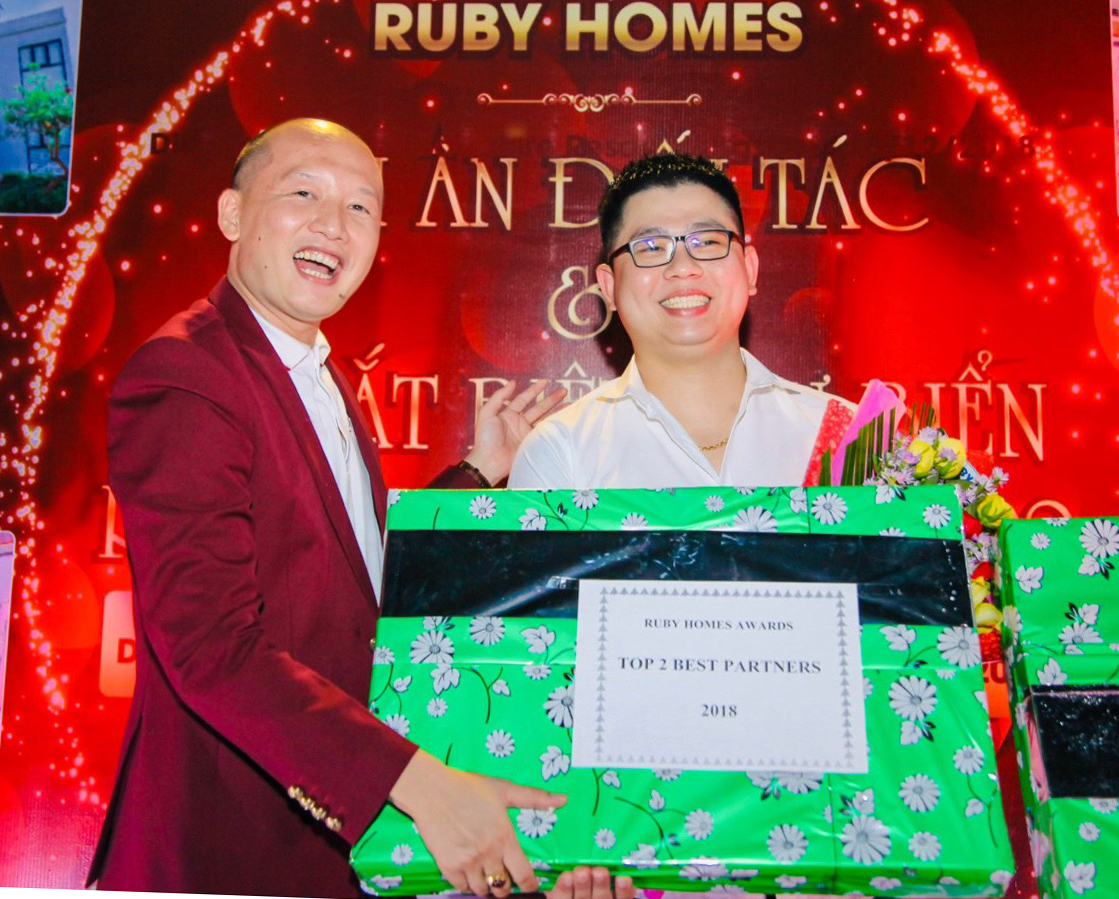 Anh Đinh Tiến Dũng (trái), Giám đốc Ruby Homes tặng quà tri ân cho đối tác.
