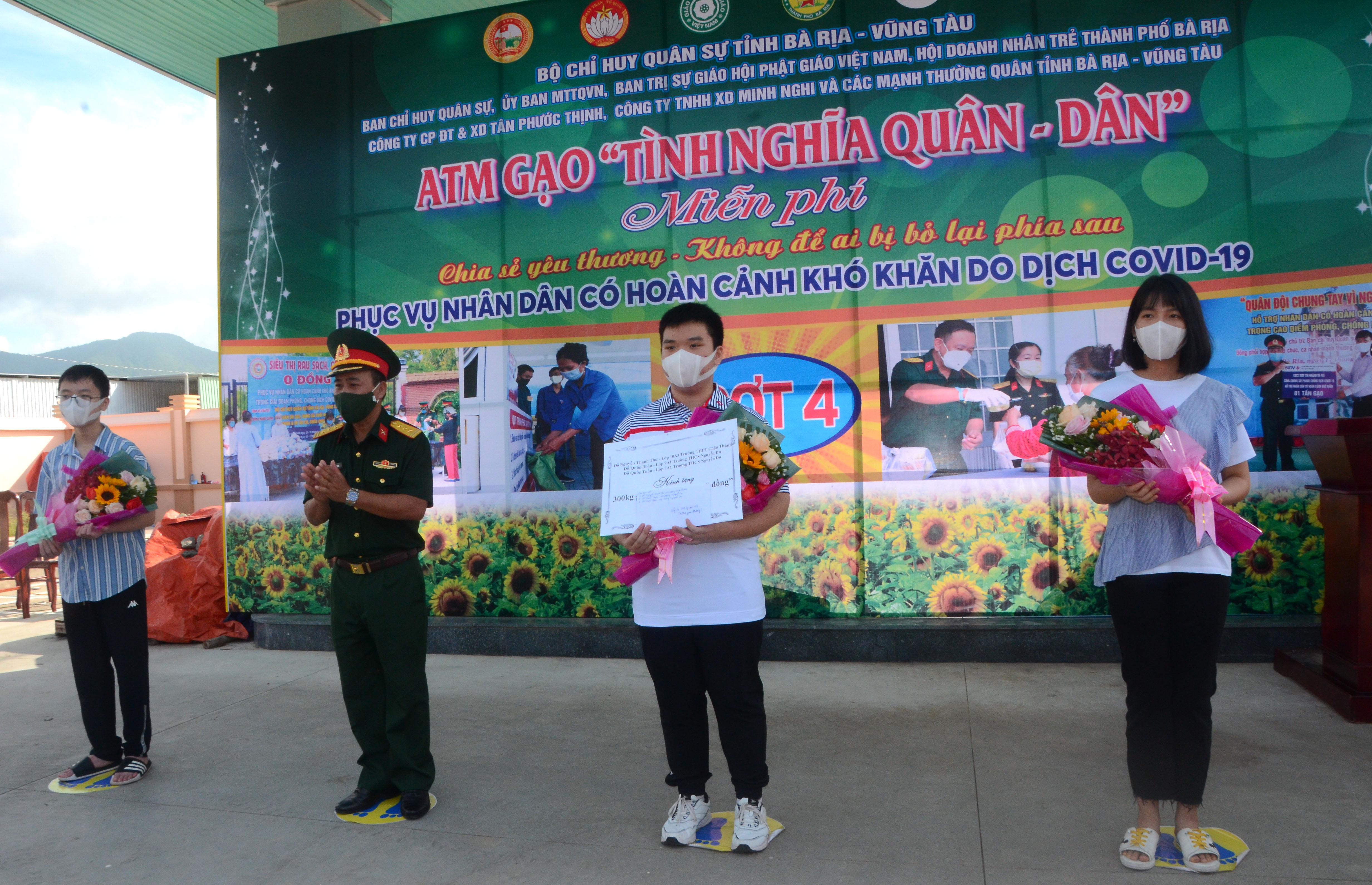  Em Đỗ Quốc Đoàn (thứ 2 từ phải qua) và Đỗ Quốc Tuấn cùng chị họ Đỗ Nguyễn Thanh Thư ủng hộ 300kg gạo cho cây “ATM gạo 0 đồng” tại Ban CHQS TP. Bà Rịa.