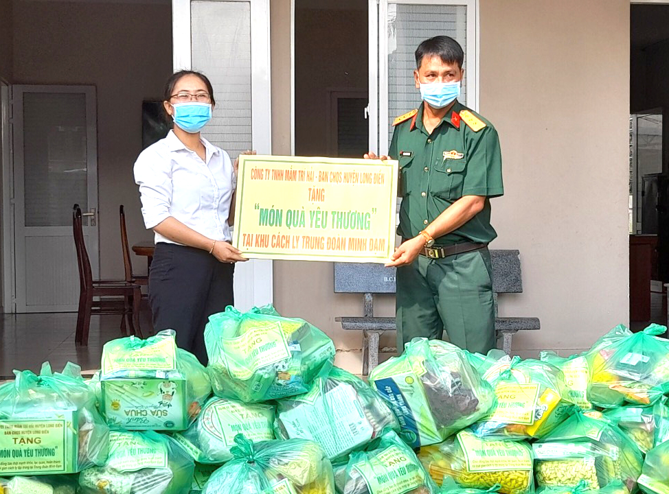Đại diện Công ty TNHH Mắm Trí Hải tặng nhu yếu phẩm cho công dân đang cách ly tại khu cách ly Trung đoàn Minh Đạm thông qua Ban CHQS huyện Long Điền.