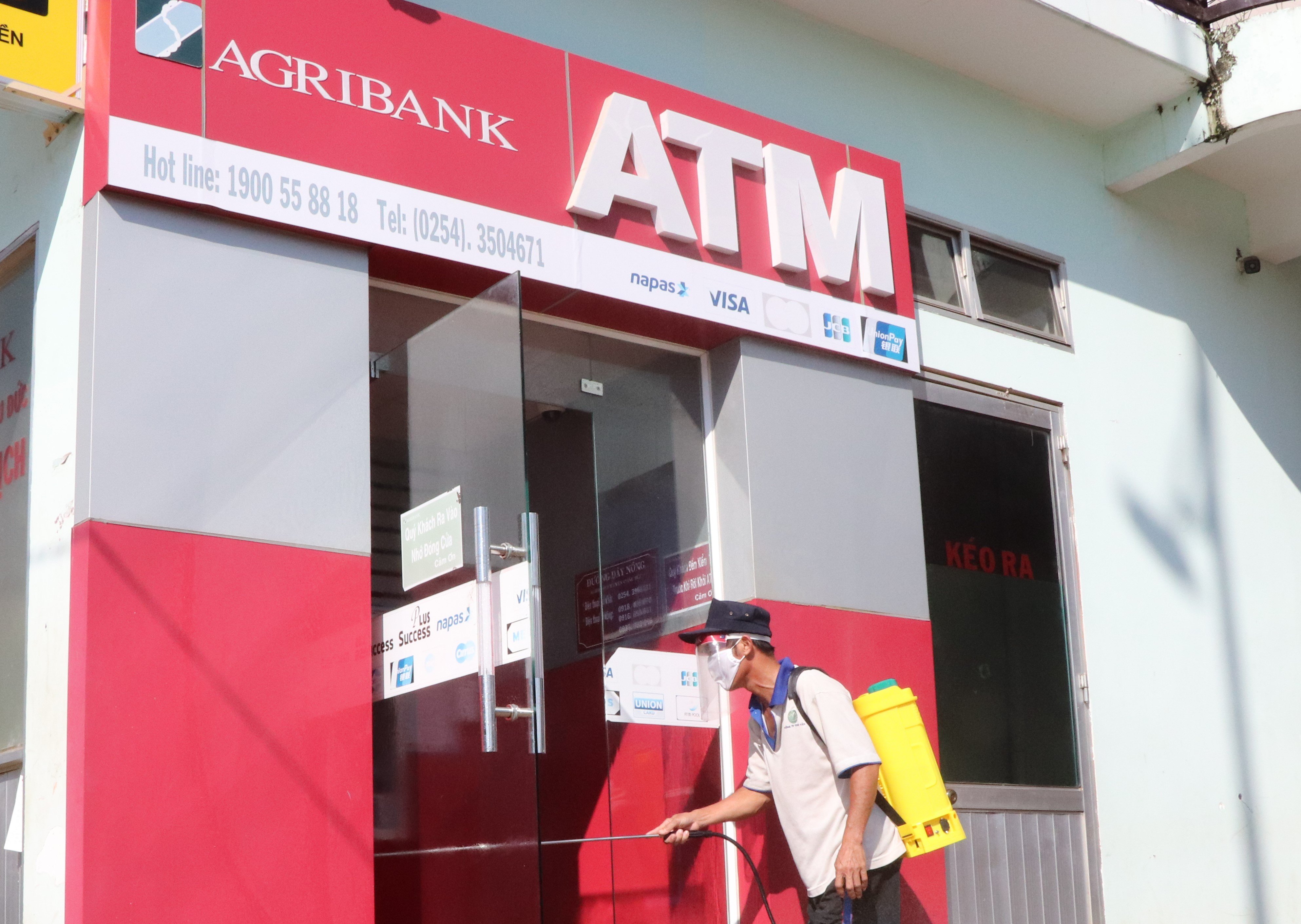 Nhân viên phun khử khuẩn tại cây ATM ở Phòng giao dịch Agribank TT. Ngãi Giao (huyện Châu Đức).