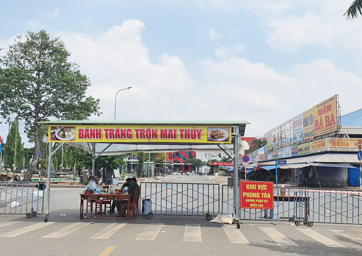 Lực lượng chức năng làm nhiệm vụ tại chốt phong tỏa ở chợ Bà Rịa. Ảnh: TUYẾT MAI