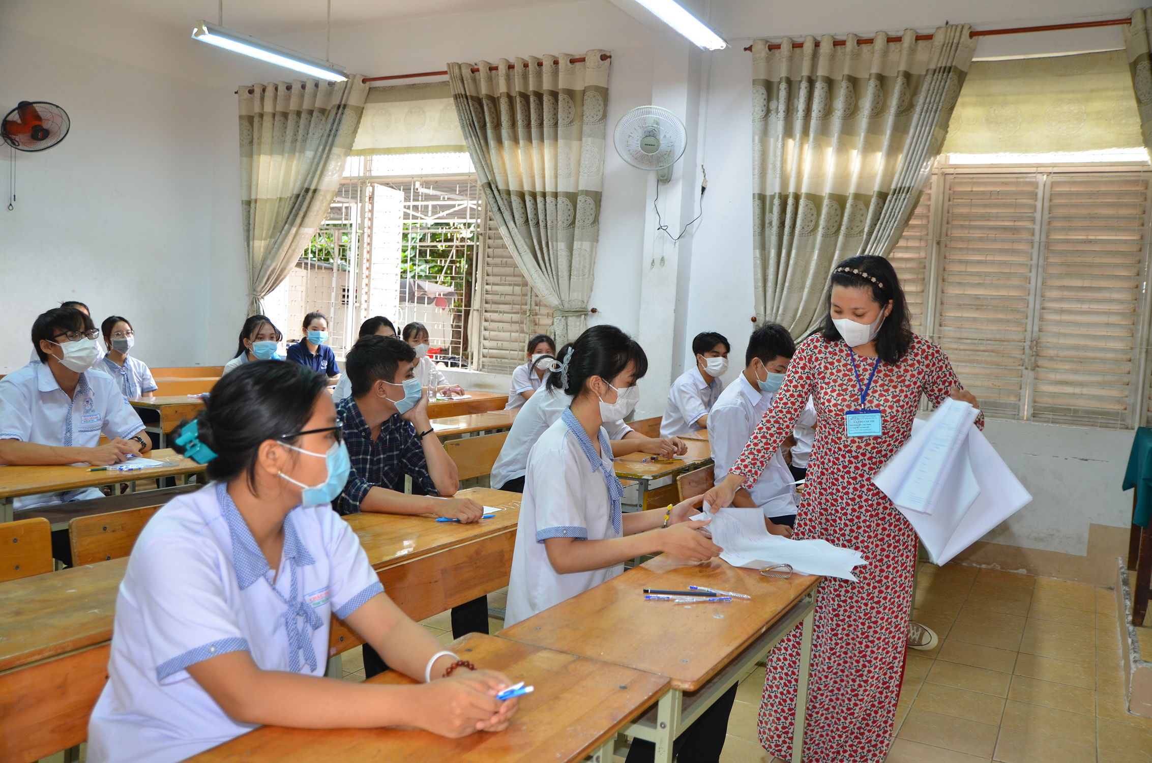 Giám thị tại điểm thi Trường THPT Châu Thành, TP. Bà Rịa phát giấy thi cho TS. Ảnh: DIỄM QUỲNH