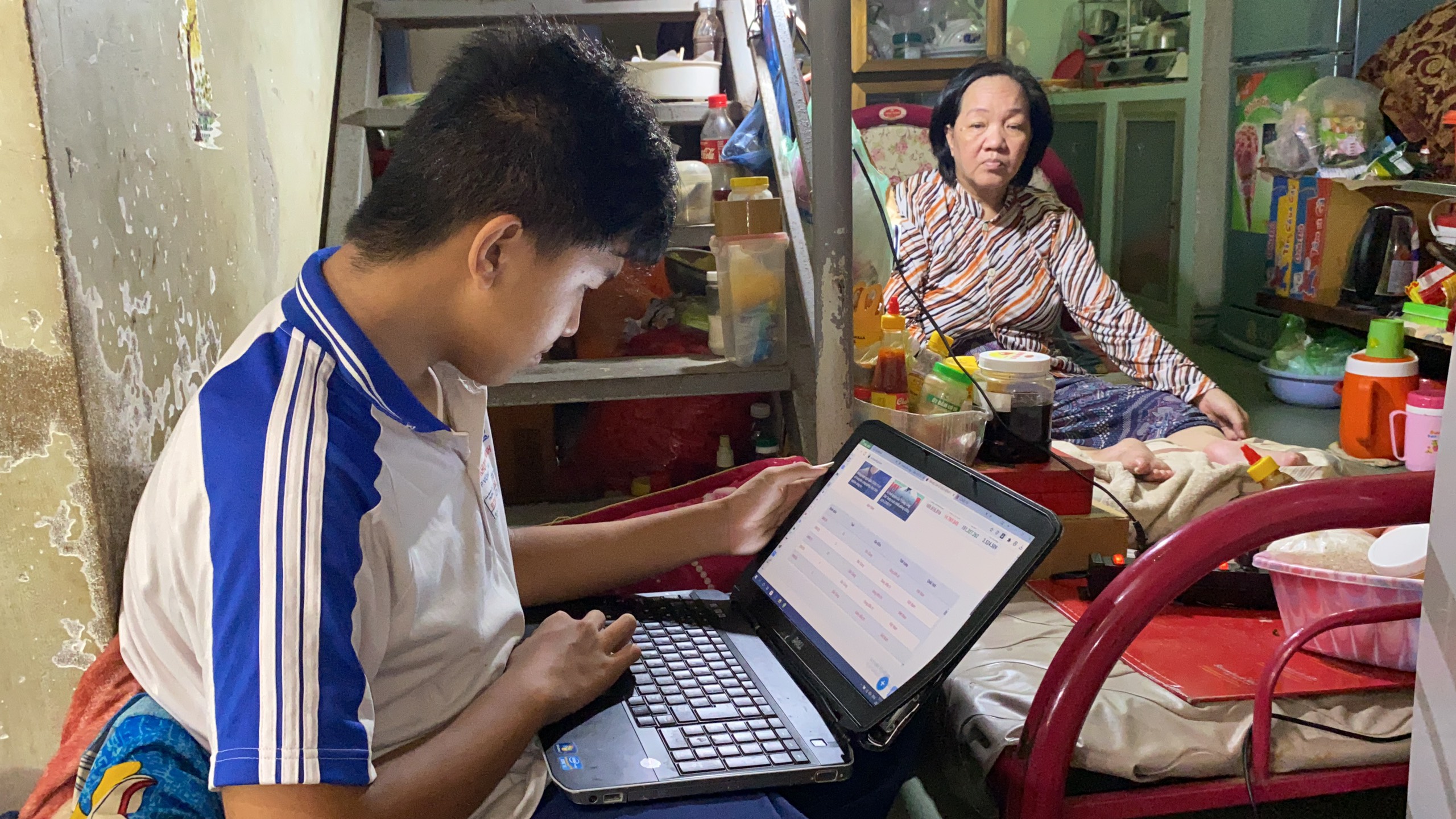 Tuấn bố trí chỗ học và chỗ ngủ ngay chân cầu thang, sát bên giường mẹ nằm để giúp khi mẹ cần.