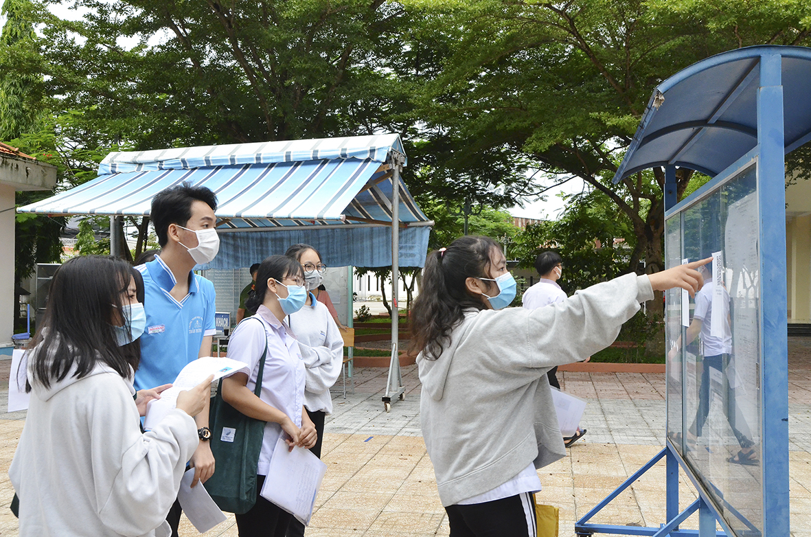 Thí sinh tại điểm thi Trường THPT Trần Hưng Đạo, TX.Phú Mỹ xem lại danh sách trước giờ thi. Ảnh: DIỄM QUỲNH