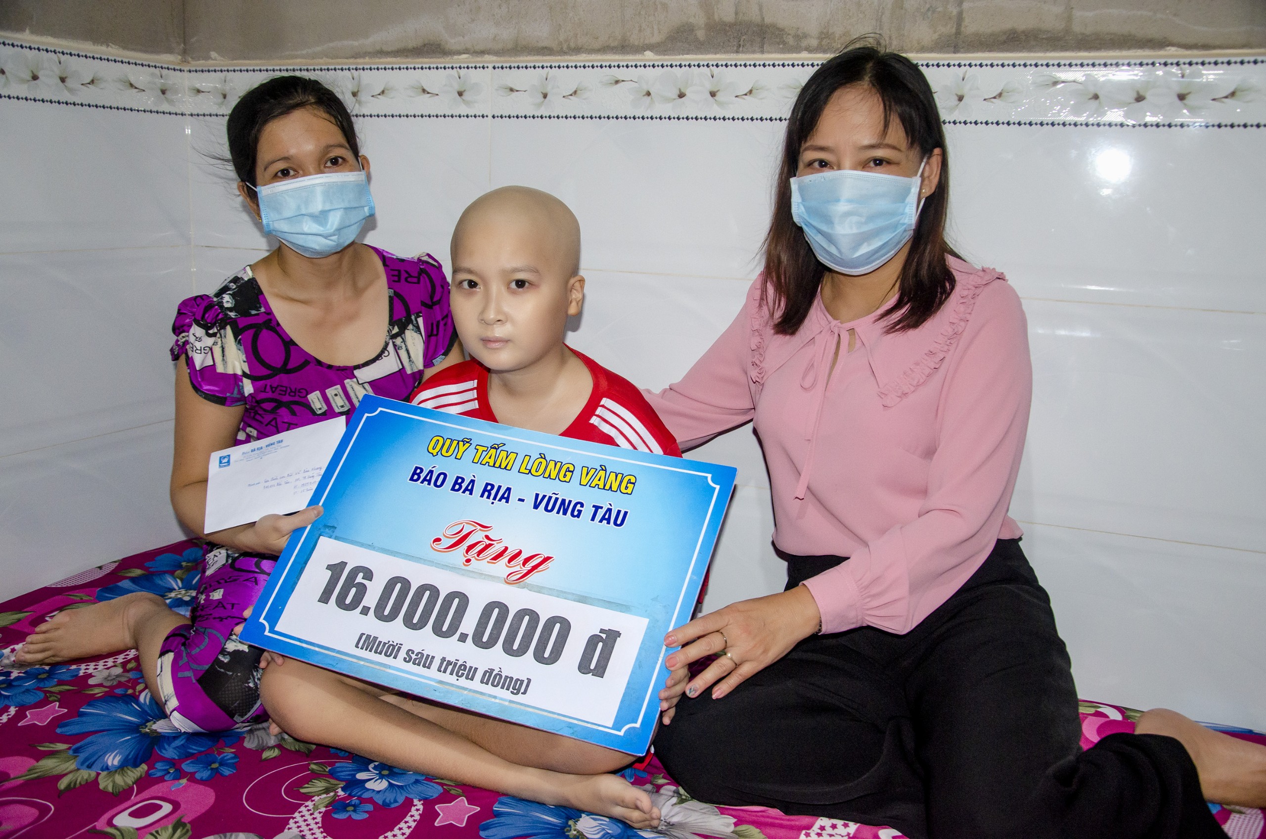 Bà Đỗ Nguyễn Hoàng Dung, Quyền Tổng Biên tập Báo BR-VT trao tiền hỗ trợ của Quỹ “Tấm lòng vàng” cho gia đình cháu Bùi Võ Bảo Khang, HS lớp 7 trường THCS Ngô Sĩ Liên (TP. Vũng Tàu).
