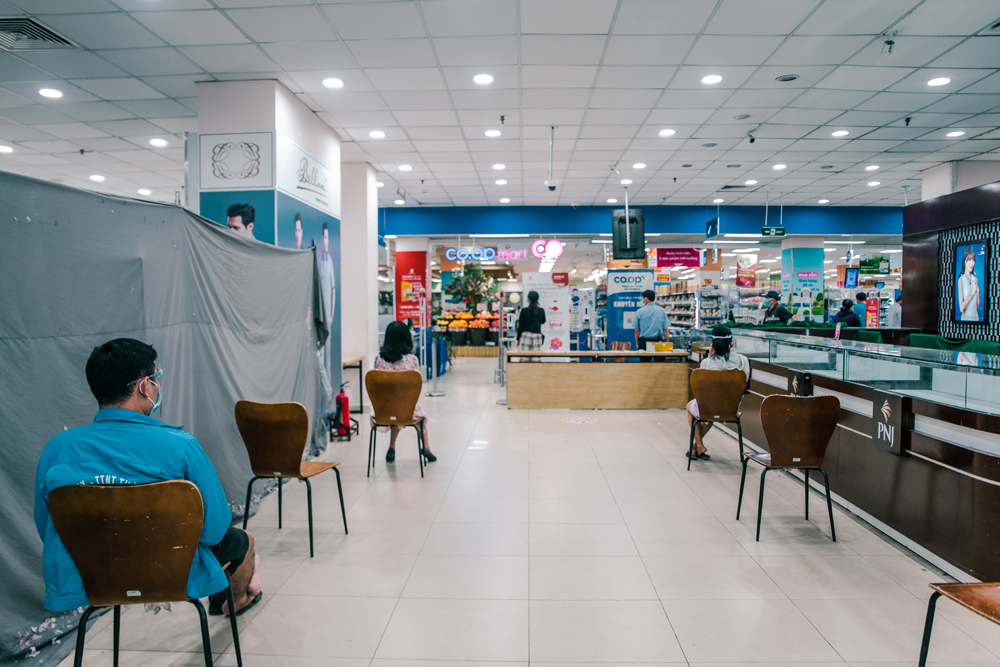 … và được bố trí ngồi giãn cách chờ đến lượt vào mua hàng.
