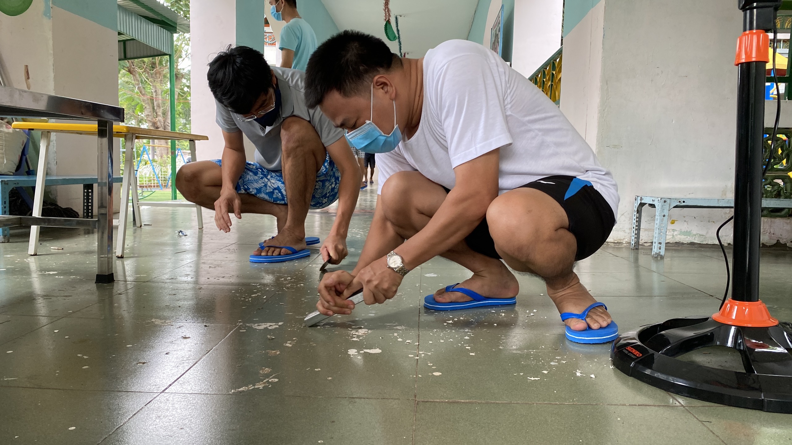 Anh Vũ Tá Huế và anh Đặng Huy Tài - Kỹ sư/CG Xưởng ĐL-TĐH Nhà máy Đạm Phú Mỹ sửa chữa lại nền gạch men trong khu cách ly.