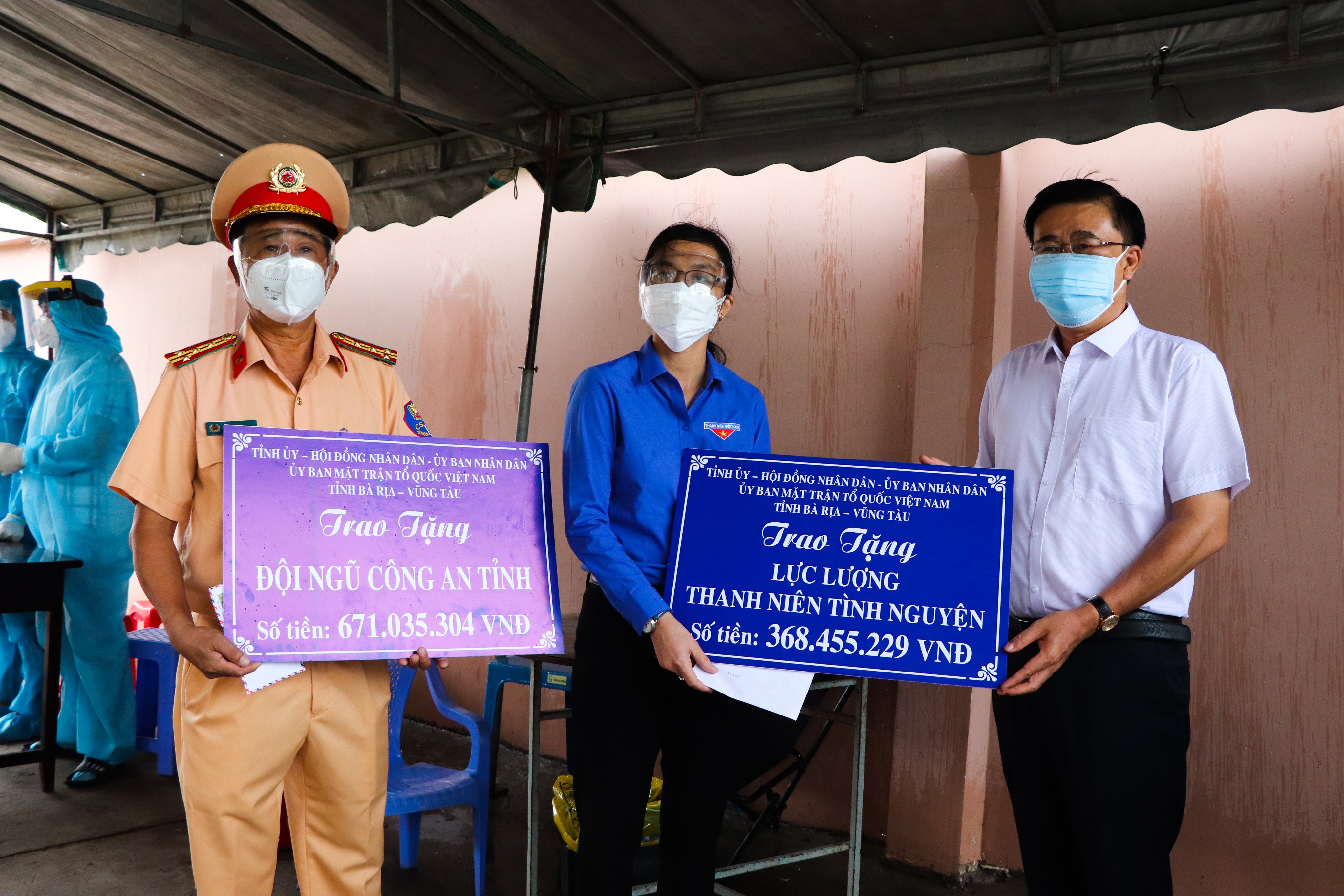 Ông Huỳnh Văn Danh (bên phải) trao tiền cho các lực lượng đang thực hiện nhiệm vụ tại các chốt kiểm tra liên ngành phòng, chống dịch COVID-19.
