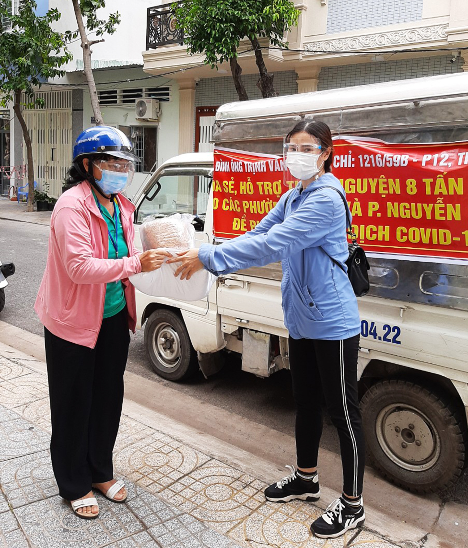 Đại diện gia đình ông Hậu trao quà cho người dân phường Nguyễn An Ninh.
