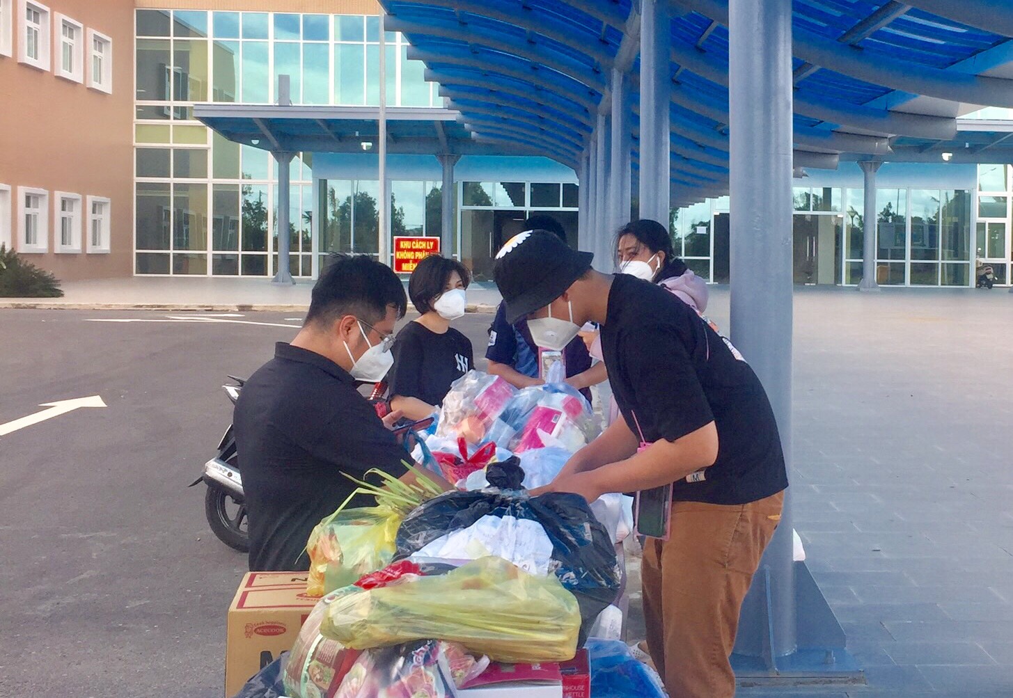 Đội tình nguyện kiểm tra phân loại đồ dùng cá nhân, nhu yếu phẩm do người nhà bệnh nhân nhờ chuyển vào bên trong khu điều trị cho bệnh  nhân.