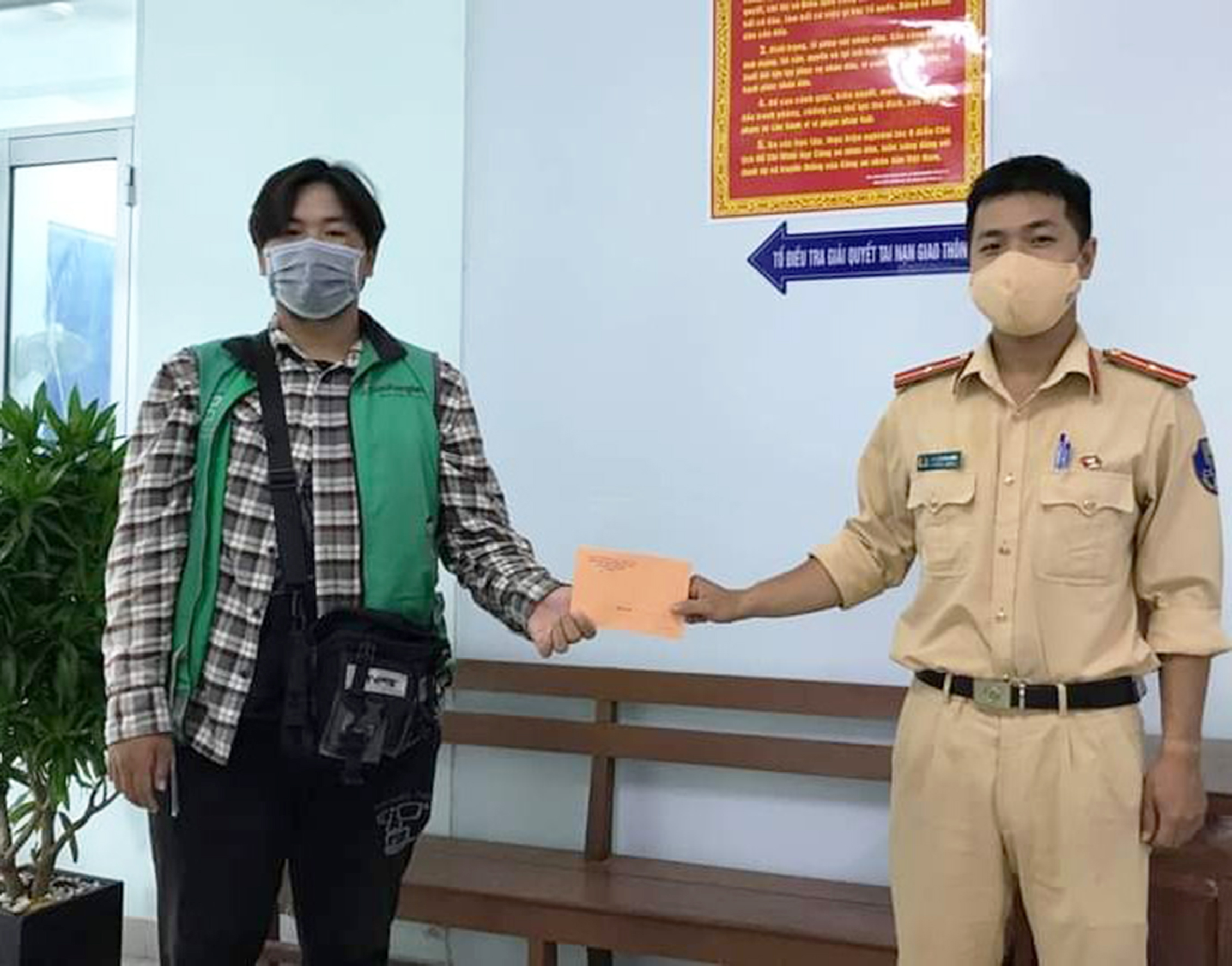Đại diện Đội CSGT, Công an TP. Bà Rịa trao lại số tiền đánh rơi cho anh Dương. 