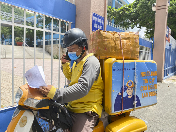 Anh Nguyễn Ngọc Minh, nhân viên giao hàng Bưu điện tỉnh liên lạc với khách để giao hàng.