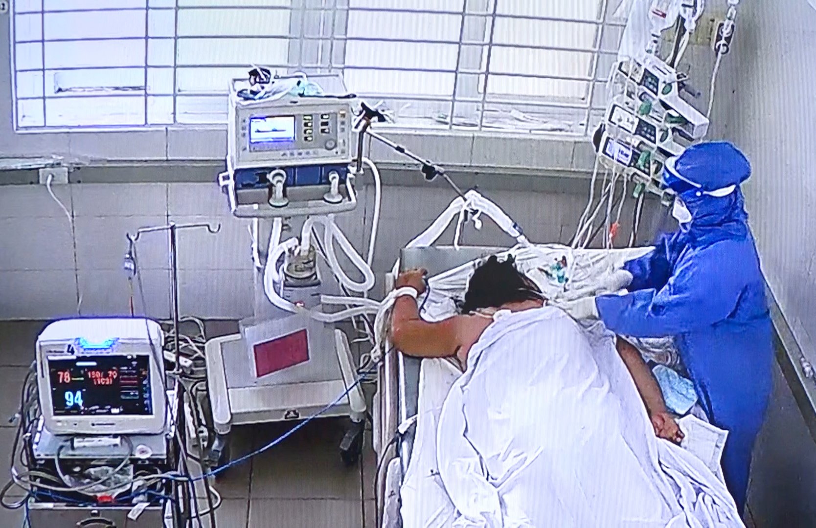 Bác sĩ thăm khám cho bệnh nhân COVID-19 nặng tại phòng hồi sức, TTYT huyện Long Điền. Ảnh: NHẬT LINH (chụp qua màn hình theo dõi bệnh nhân).