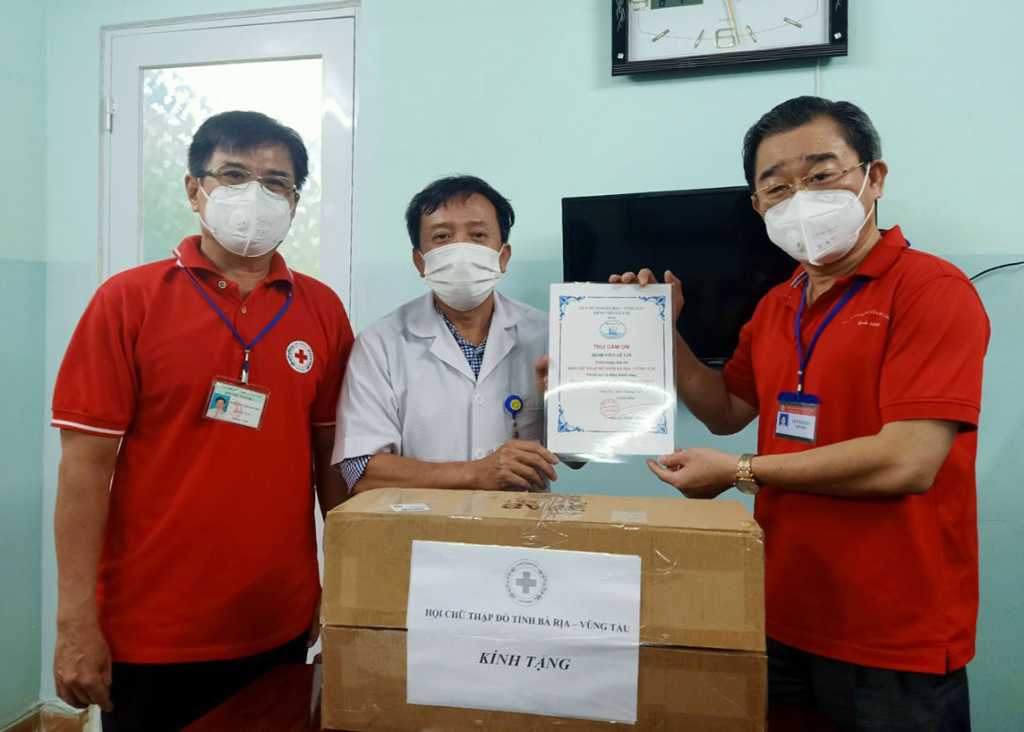 Ông Lê Văn Hậu (bìa phải), Chủ tịch Hội Chữ thập đỏ tỉnh trao vật tư y tế cho bác sĩ Nguyễn Thanh Phước, Giám đốc Bệnh viện Vũng Tàu.