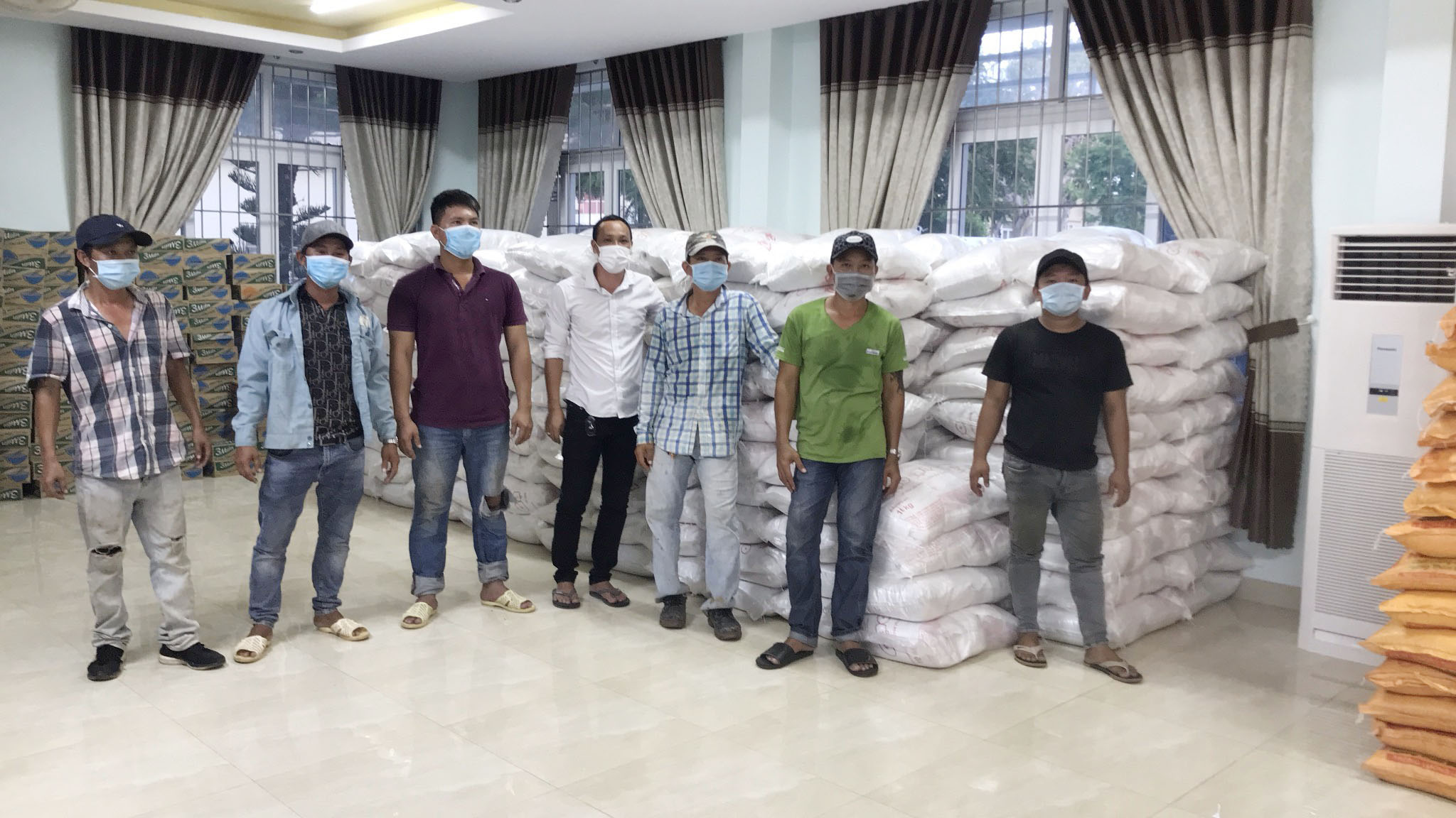 Nhóm “cửu vạn” tình nguyện vui vẻ chụp ảnh lưu niệm sau khi vận chuyển 10 tấn gạo vào kho.
