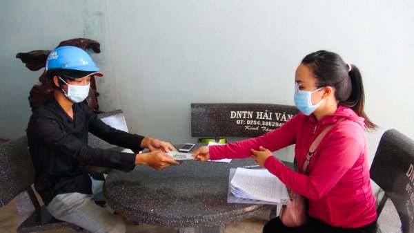 Bà Nguyễn Thị Phương Thi, công chức UBND xã An Nhứt trao 2,5 triệu đồng cho ông Nguyễn Phi Hùng (ấp An Lạc, xã An Nhứt), hộ có hoàn khó khăn do đại dịch COVID-19. Ảnh: ĐINH HÙNG