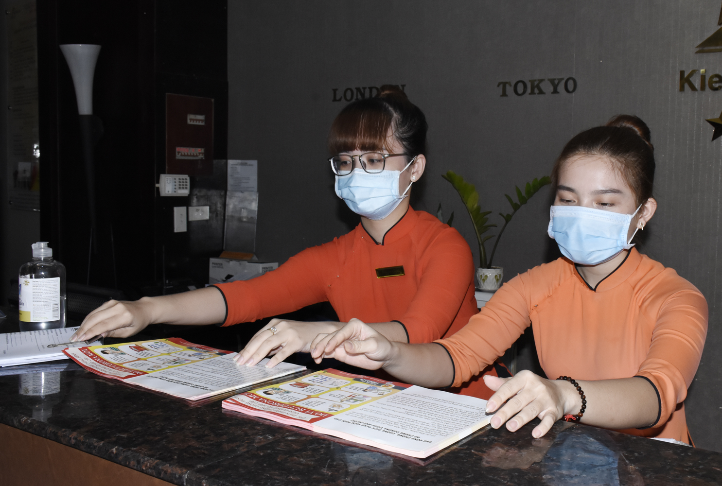Nhân viên Khách sạn Kiều Anh bày trí tờ rơi hướng dẫn phòng dịch tại quầy lễ tân hướng dẫn du khách thực hiện.