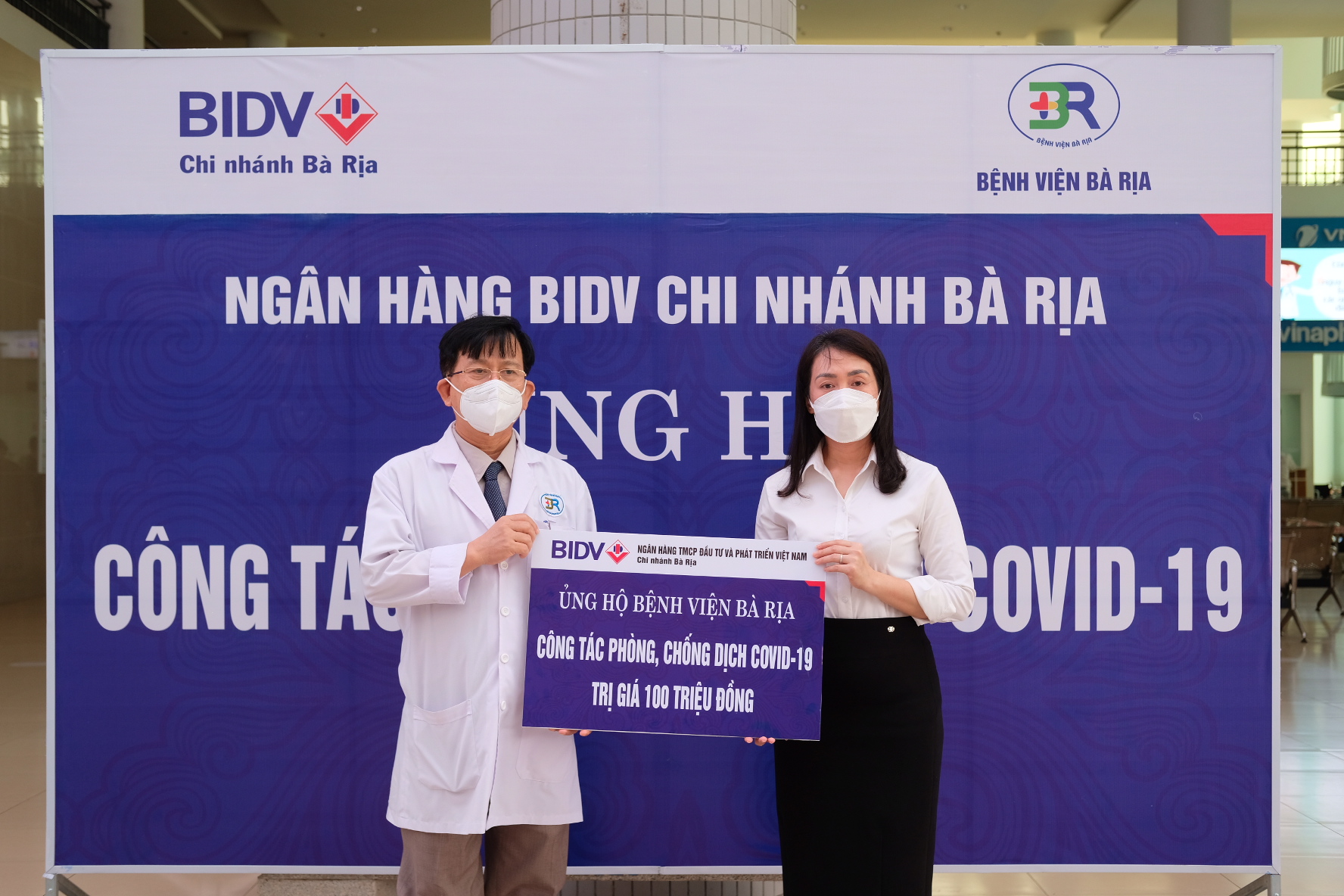 Ngoài việc trao tặng thiết bị công nghệ thông tin để khai báo y tế điện tử, mới đây BIDV Bà Rịa còn ủng hộ 100 triệu đồng cho bệnh viện Bà Rịa vào hoạt động phòng chống COVID-19. Trong ảnh: Đại diện bệnh viện Bà Rịa nhận tấm bảng tượng trưng do bà Bà Nguyễn Thanh Thủy, Giám đốc BIDV Bà Rịa trao tặng.