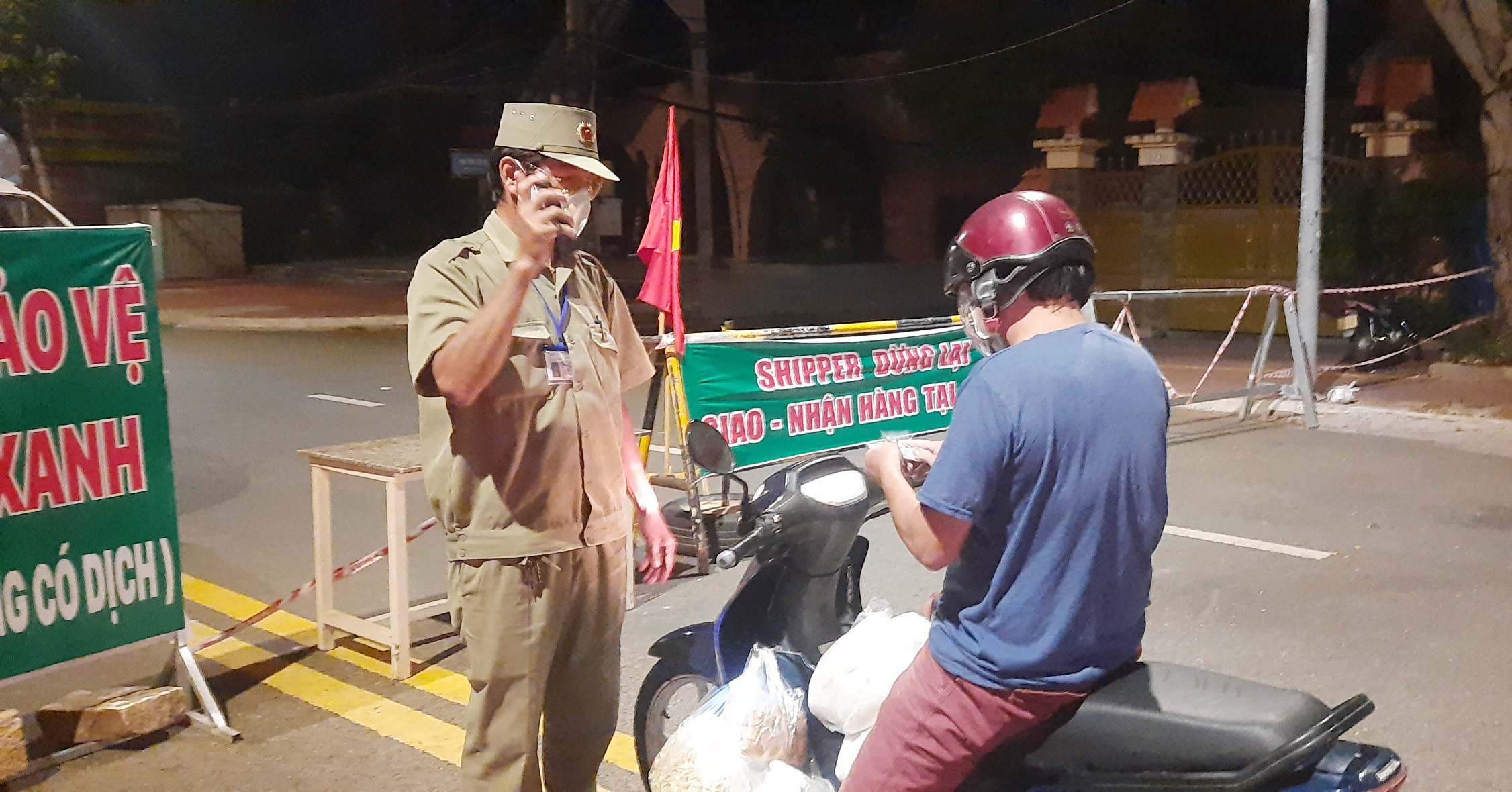 Lực lượng dân phòng kiểm tra giấy của người đi đường tại Chốt bảo vệ vùng xanh đường Võ Thị Sáu.  Ảnh: DIỄM QUỲNH