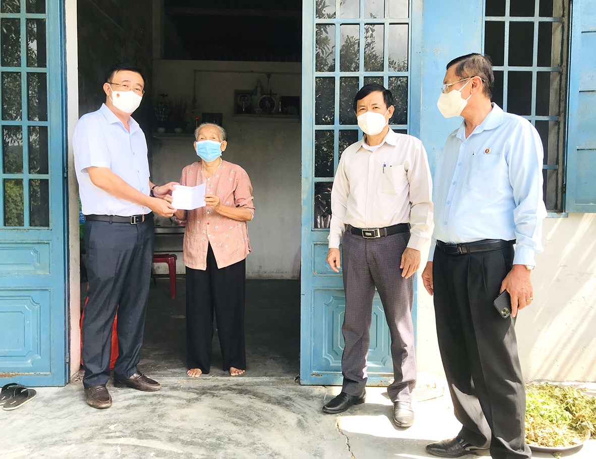 Ông Huỳnh Văn Danh, Ủy viên Ban Thường vụ Tỉnh ủy, Trưởng Ban Dân Vận Tỉnh ủy tặng quà, động viên bà Nguyễn Thi Phúc, thôn Tân Long, xã Châu Pha. Ảnh: MỸ LƯƠNG