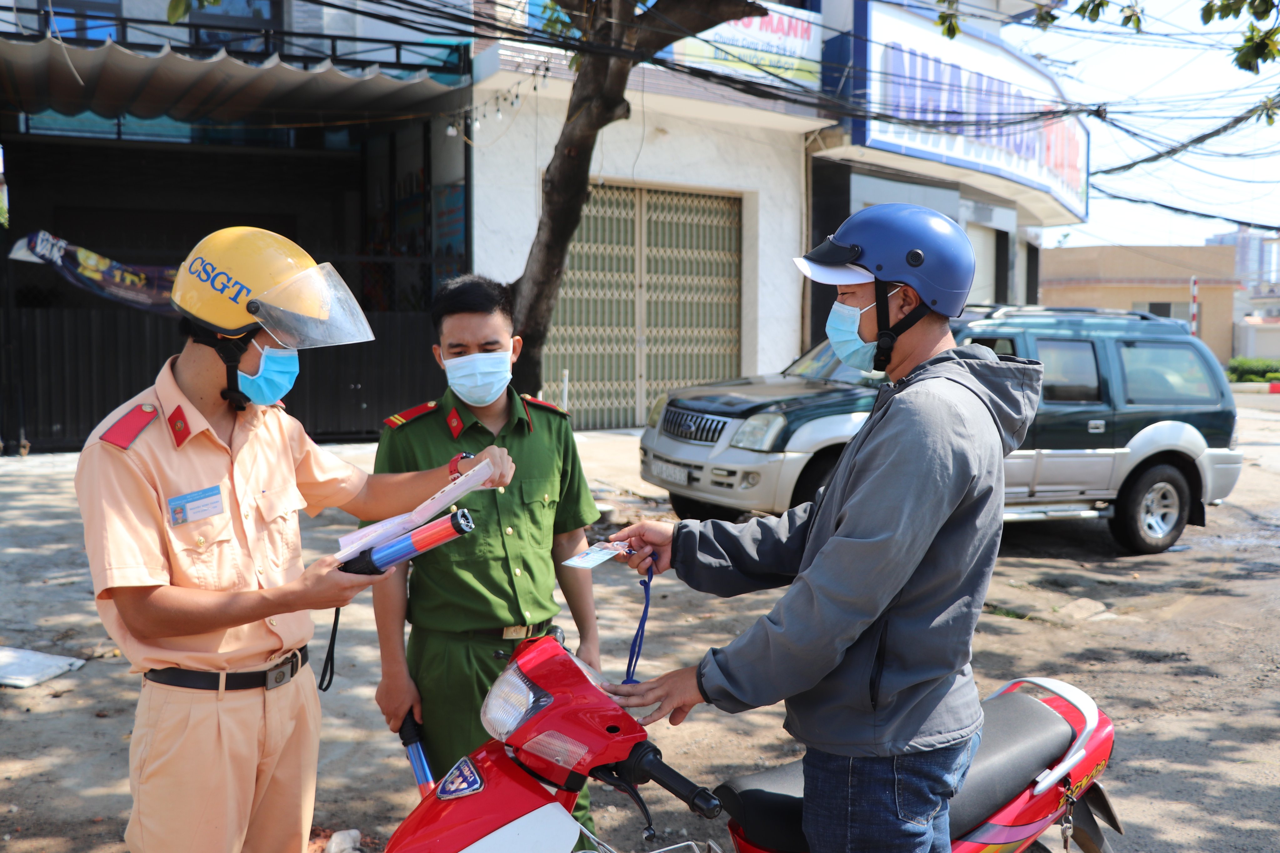CSGT Công an huyện Long Điền phối hợp với Công an xã Phước Tỉnh kiểm tra giấy đi đường của 1 người dân. Ảnh: ĐINH HÙNG