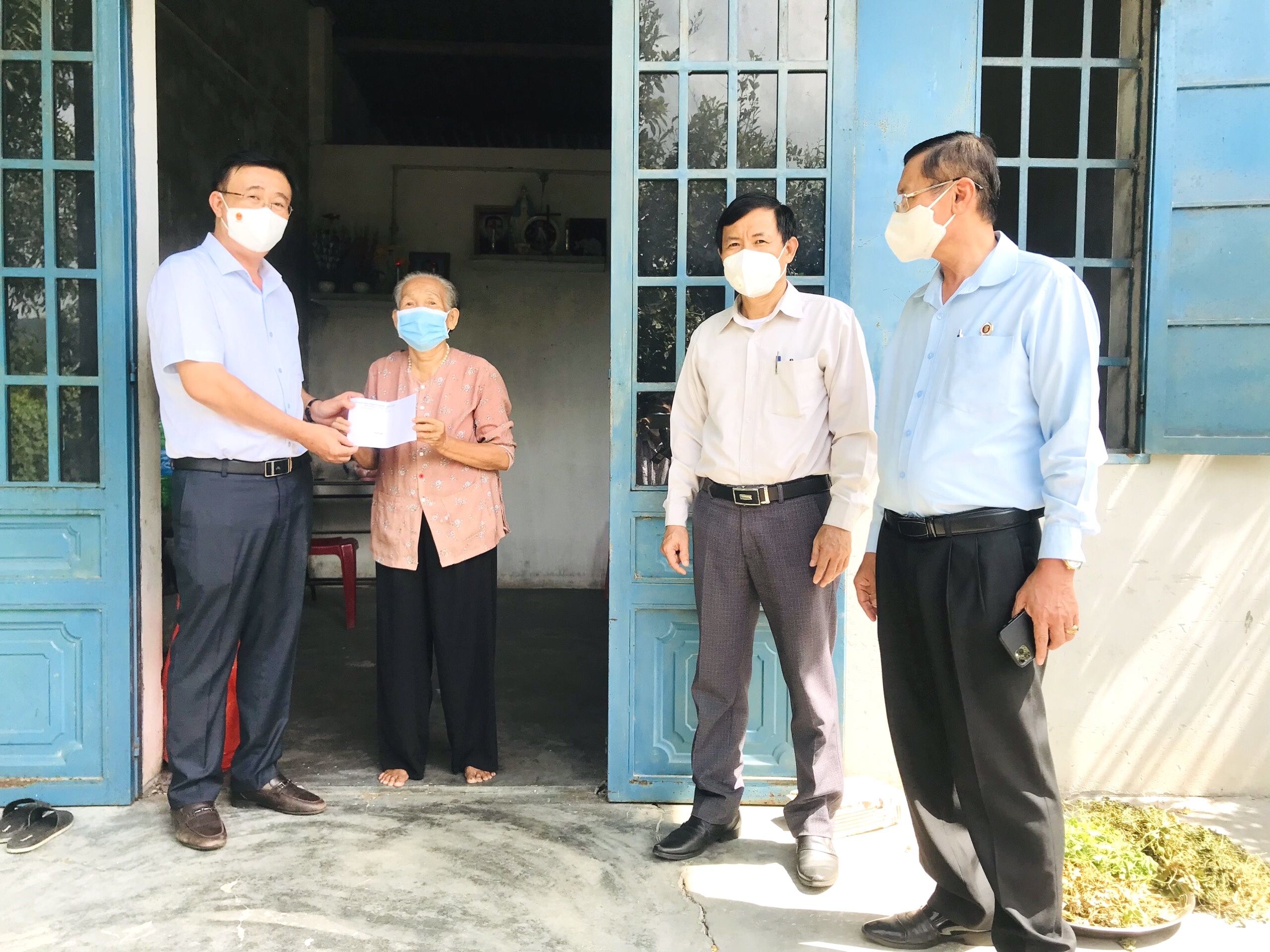 Ông Huỳnh Văn Danh, Ủy viên Ban Thường vụ Tỉnh ủy, Trưởng Ban Dân Vận Tỉnh ủy tặng quà, động viên bà Nguyễn Thị Phúc, thôn Tân Long, xã Châu Pha. Ảnh: MỸ LƯƠNG