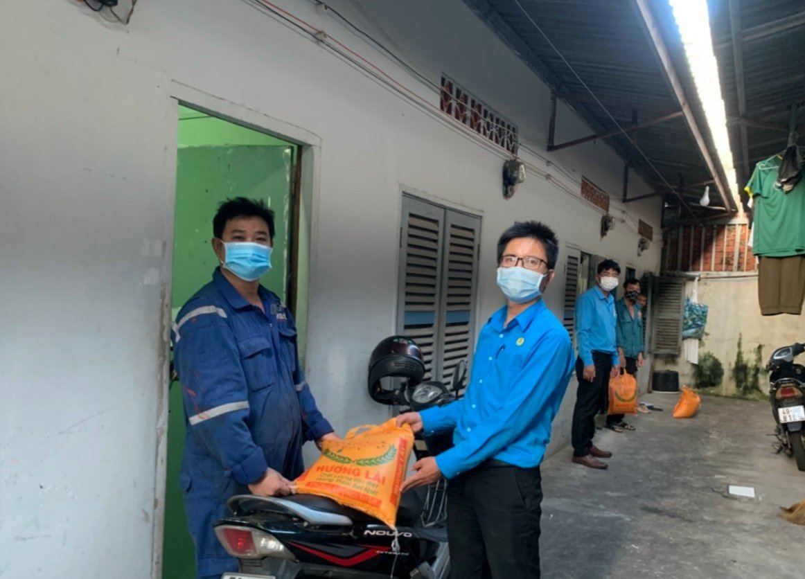 Đại diện CĐ Các KCN tỉnh tặng gạo cho công nhân lao động tại một khu nhà trọ. Ảnh: TUYẾT MAI