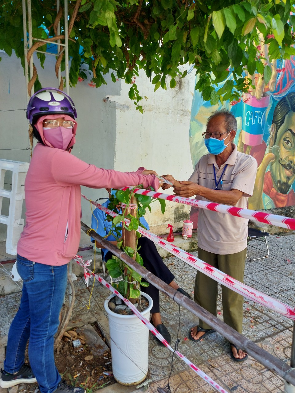 Chị Phạm Thị Hoài Phương, Chi hội trưởng Chi hội Phụ nữ khu phố 2, Hội LHPN phường Thắng Tam (trái) trao tiền mặt cho đại diện chốt trực phòng, chống COVID-19 trên địa bàn khu phố.
