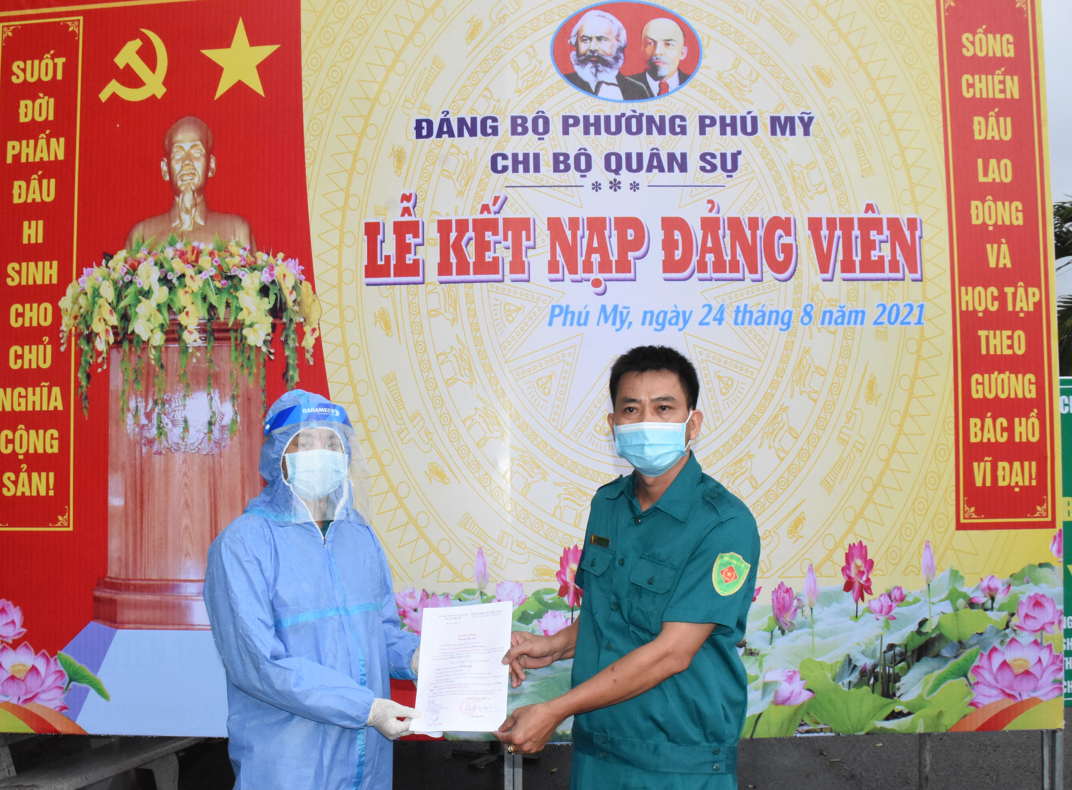 Đại diện Chi bộ Quân sự phường Phú Mỹ trao quyết định kết nạp Đảng viên cho quần chúng ưu tú Đỗ Hữu Nghĩa tại chốt bảo vệ vùng xanh khu phố Tân Phú. Ảnh: QUANG VŨ